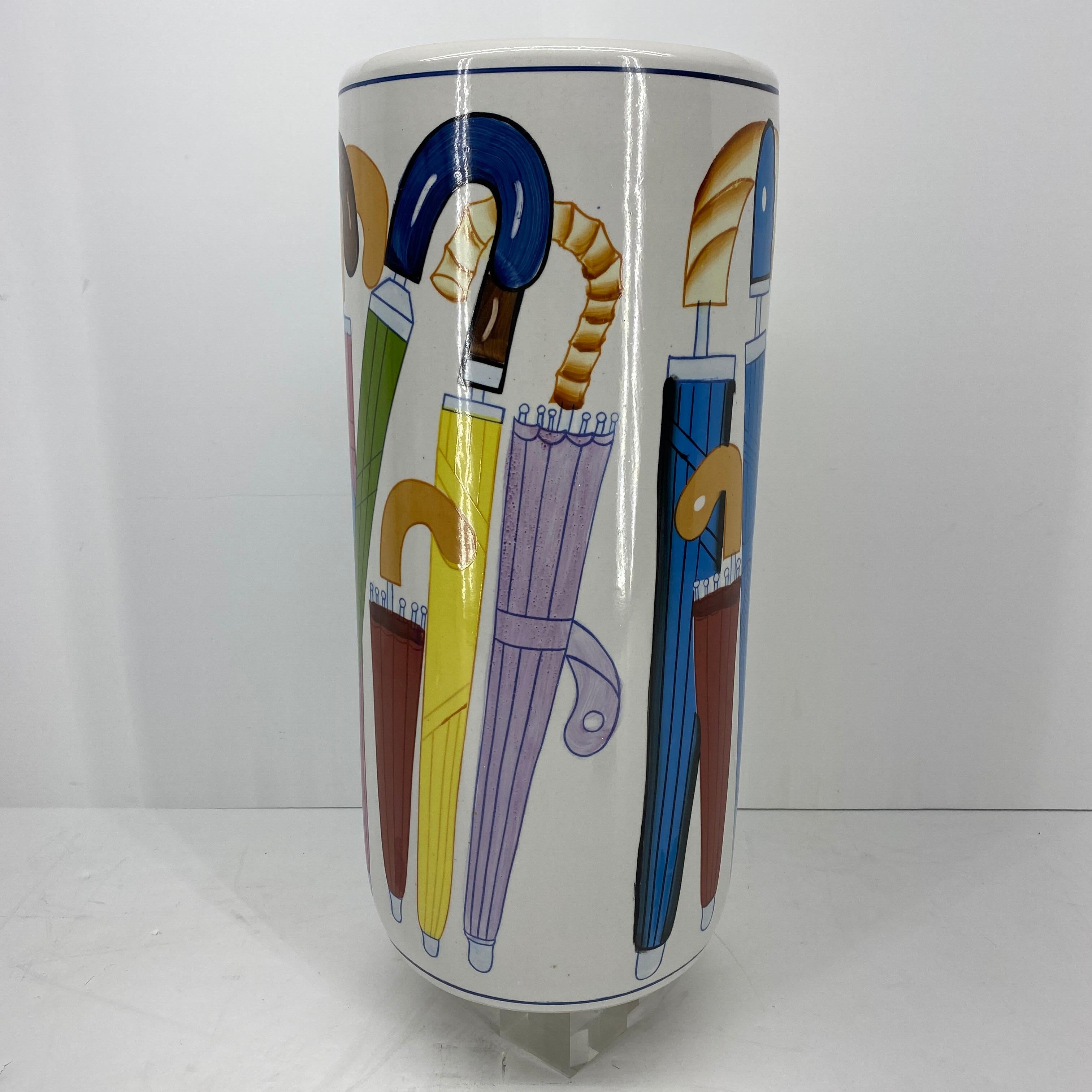 This elegant and charming Fornasetti style umbrella stand is most likely Italian from the 1950-60's.
The stand is made of white porcelain as base and is colorfully decorated with blue, pink, green, yellow and red umbrellas.
     