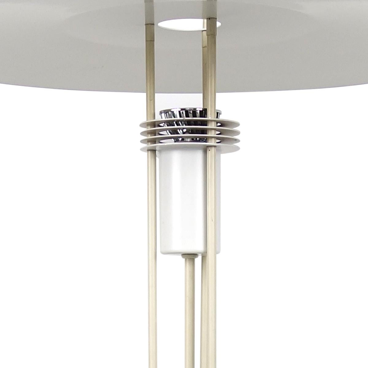 Elegant floor lamp designed and made by Danish lamp specialist Frandsen.
It consists of a round base on which three tubes have been mounted, carrying a two level shade.
The way the light comes out is really beautiful.
