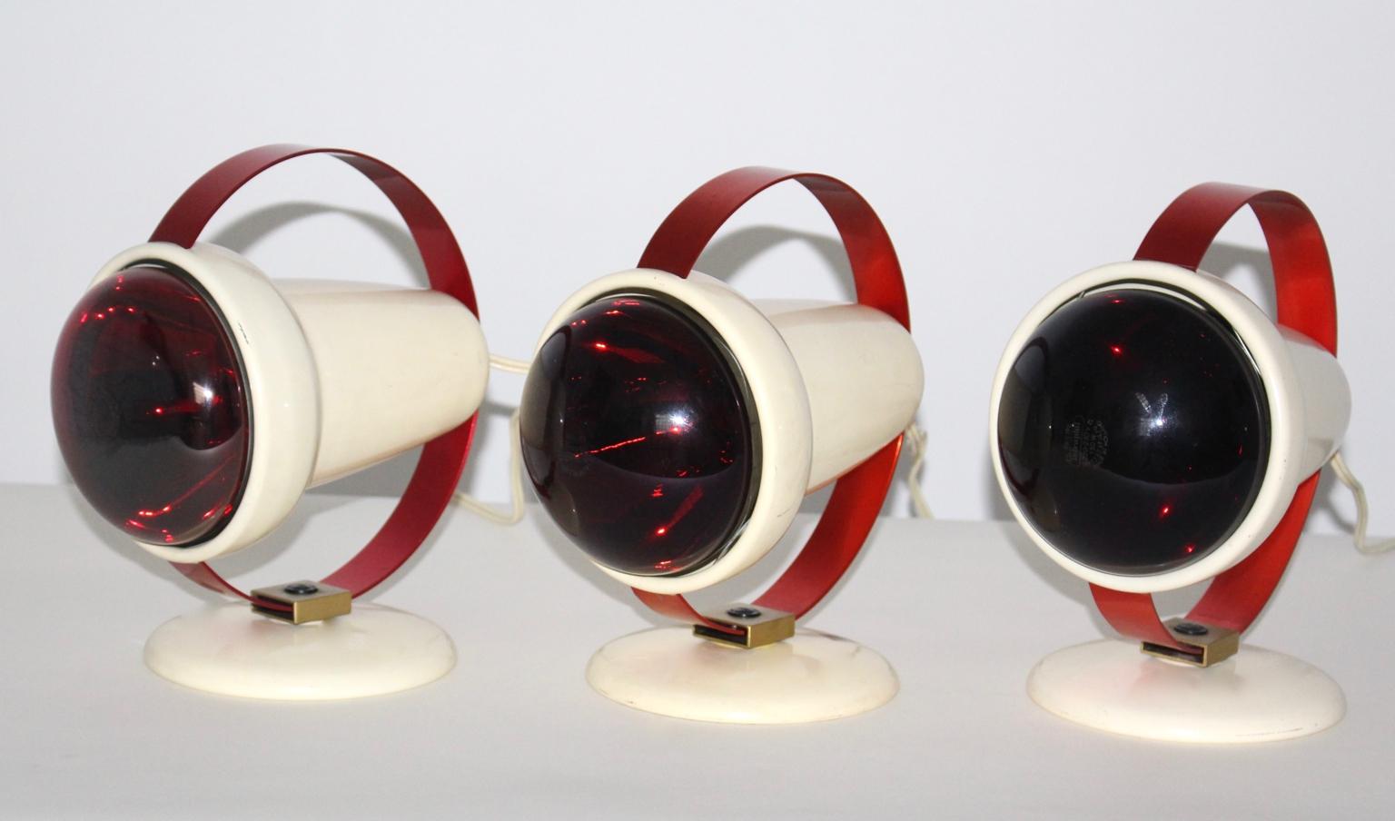 These three heater lamps were designed by the French architect and designer Charlotte Perriand and produced by Philips Netherlands.
The base was white lacquered and a red lacquered ring for supporting. Also the lamps are adjustable from right to
