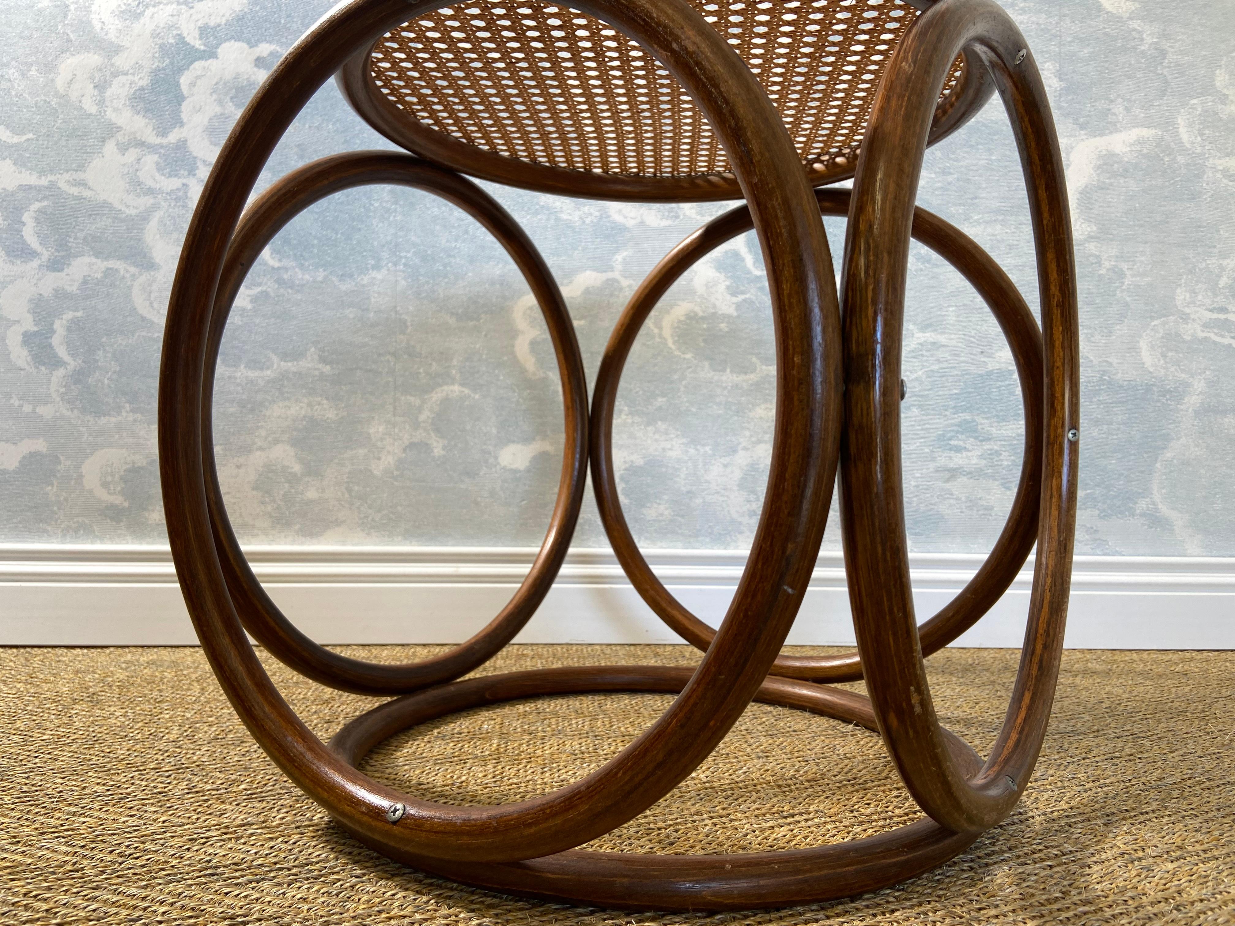 Ce charmant tabouret ou table d'appoint moderne du milieu du siècle sur 4 pieds sphériques en osier au motif de tressage viennois (Wiener Geflecht) a été fabriqué dans le style du tabouret rond à siège en canne en bois de Thonet et provient