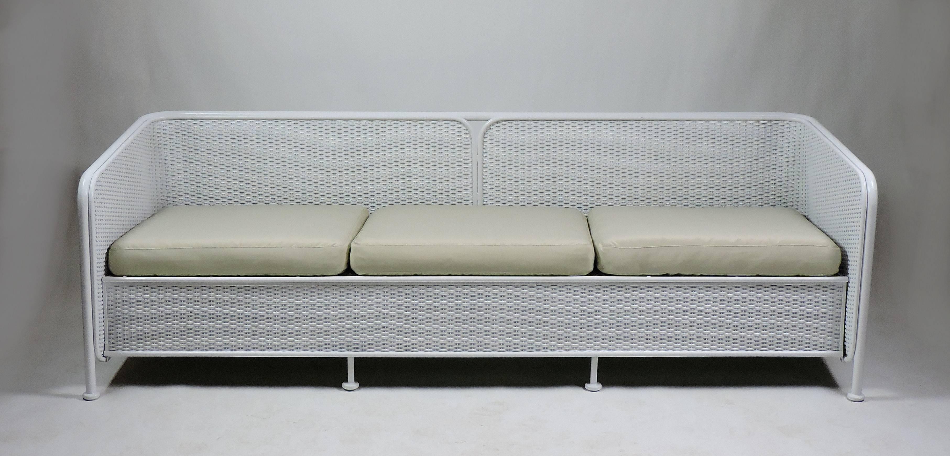 Beautiful midcentury painted wicker sofa with a metal frame that has distinctive rounded edges that give it an Art Deco look. Substantial and well made, this has been freshened up with a new coat of white paint. The cushions are only for display and