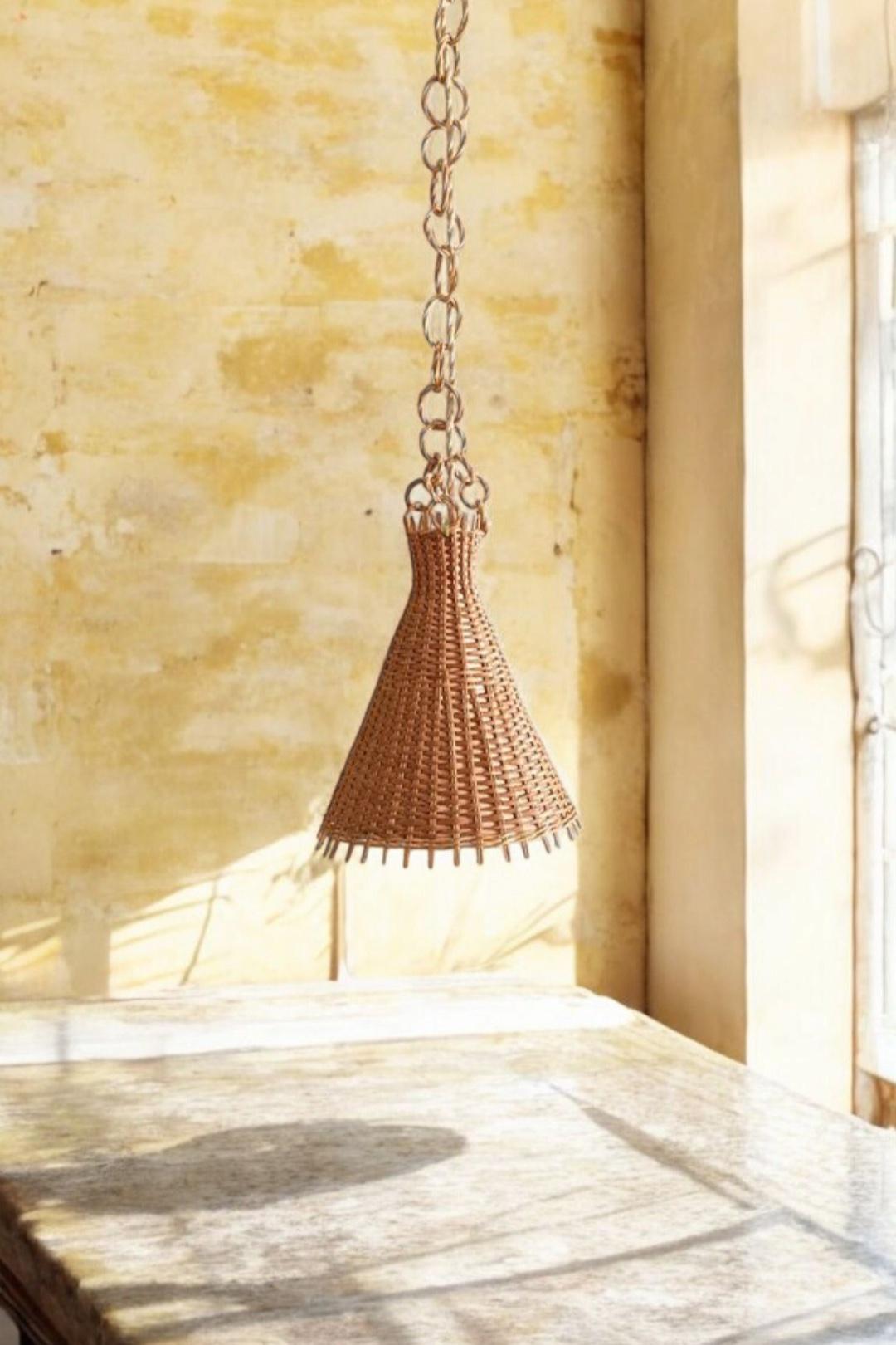 Mid-Century Modern Wicker Pendant Lamp, Spain, 1950s

Handmade in Spain circa the 1950s, this conic-shaped wicker pendant lamp is a standout example of Mid-Century Modern design. Its sculptural silhouette and hand-woven texture make it an ideal