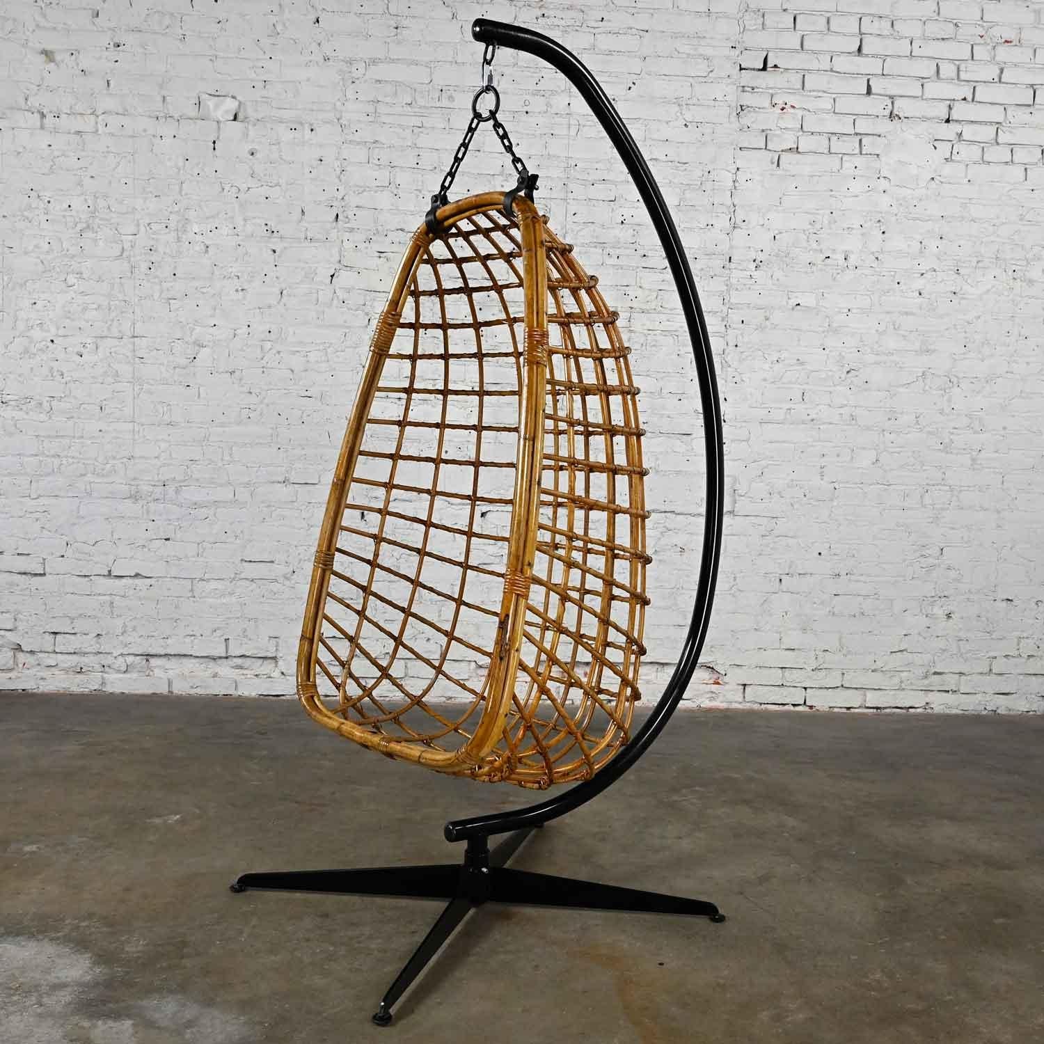 Awesome vintage Mid-Century Modern wicker rattan hanging basket chair and black painted stand. Beautiful condition, keeping in mind that this is vintage and not new so will have signs of use and wear. The basket chair itself has a fresh coat of