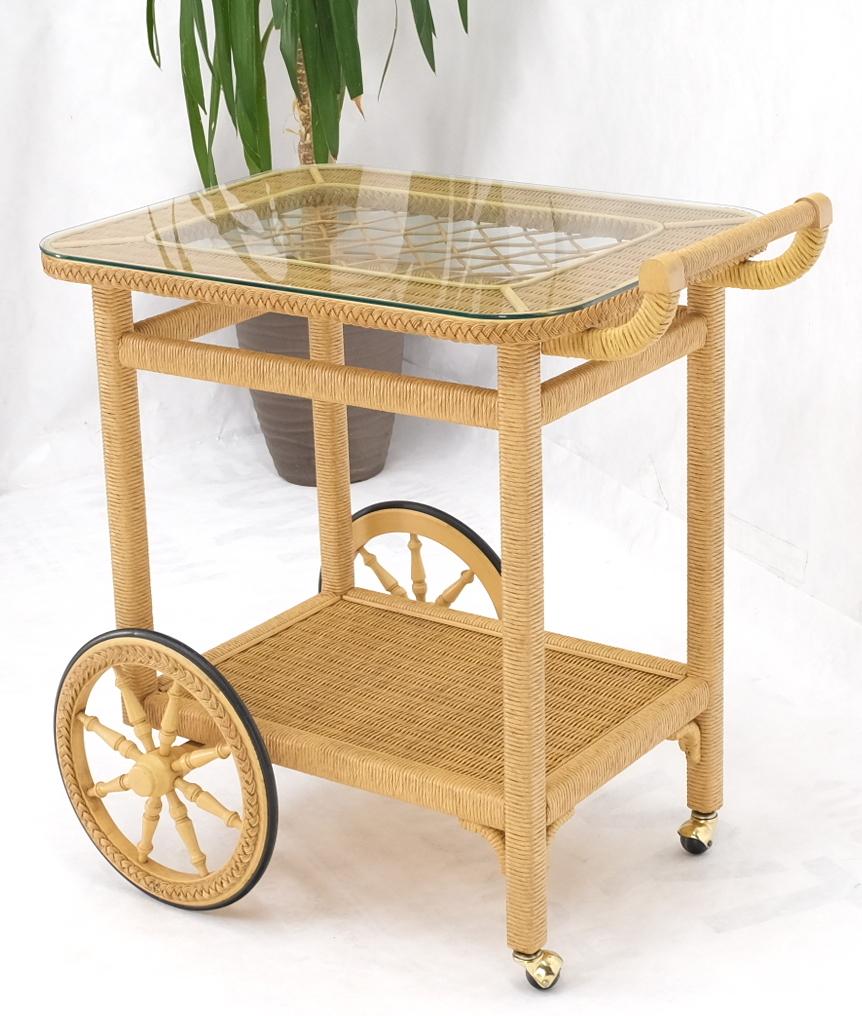 Mid century European modern wicker glass top serving cart on wagon style wheels.