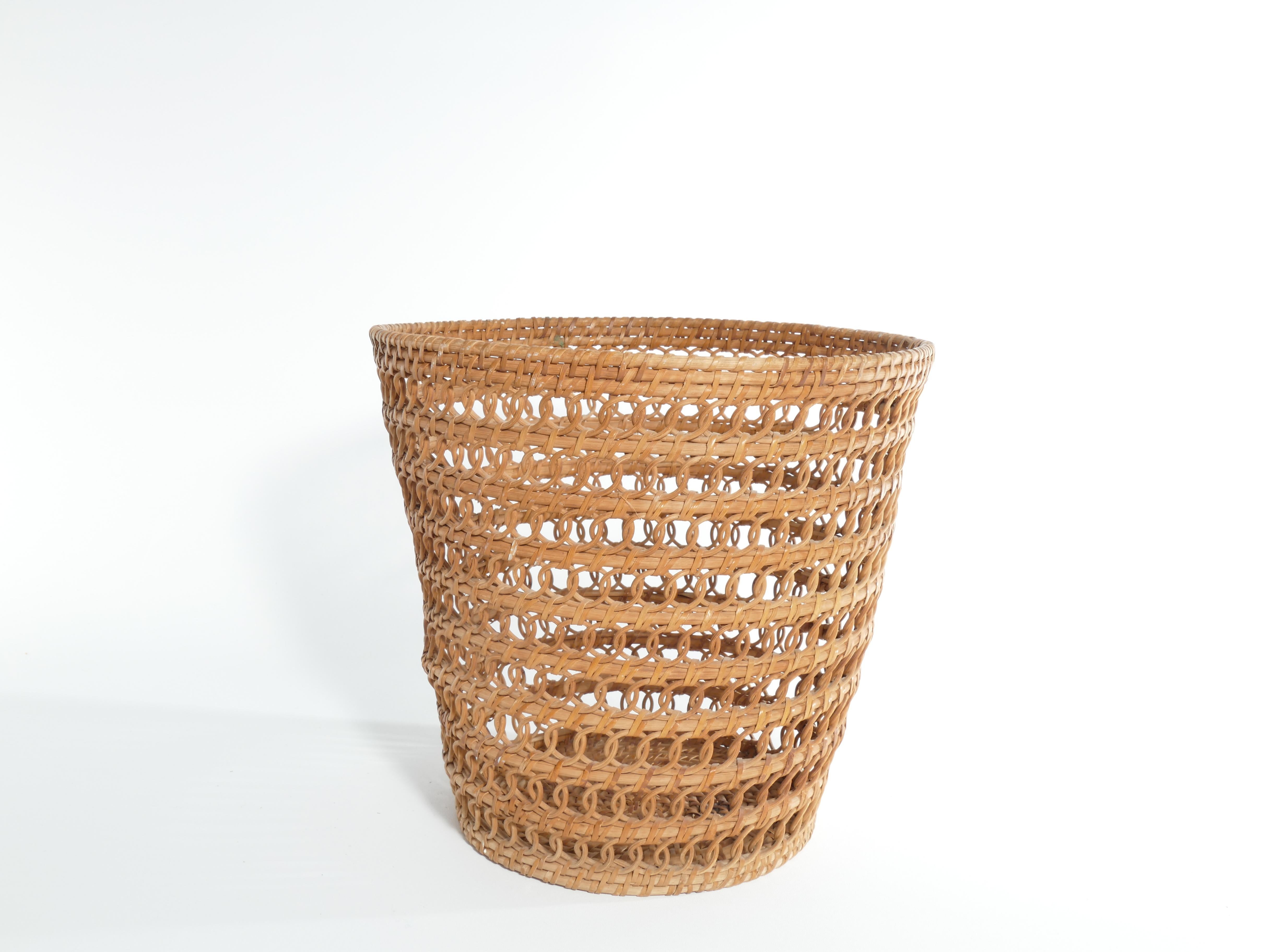 This handcrafted wicker wastebasket encapsulates the essence of mid-century modern design, boasting clean lines, organic materials, and a harmonious blend of form and function. Its gentle curves, lovely loop weave and woven texture add an element of