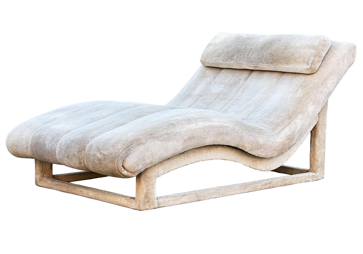 A vintage wave chaise lounge circa 1970's. Currently in its original faux fur upholstery and ready for your custom fabric.