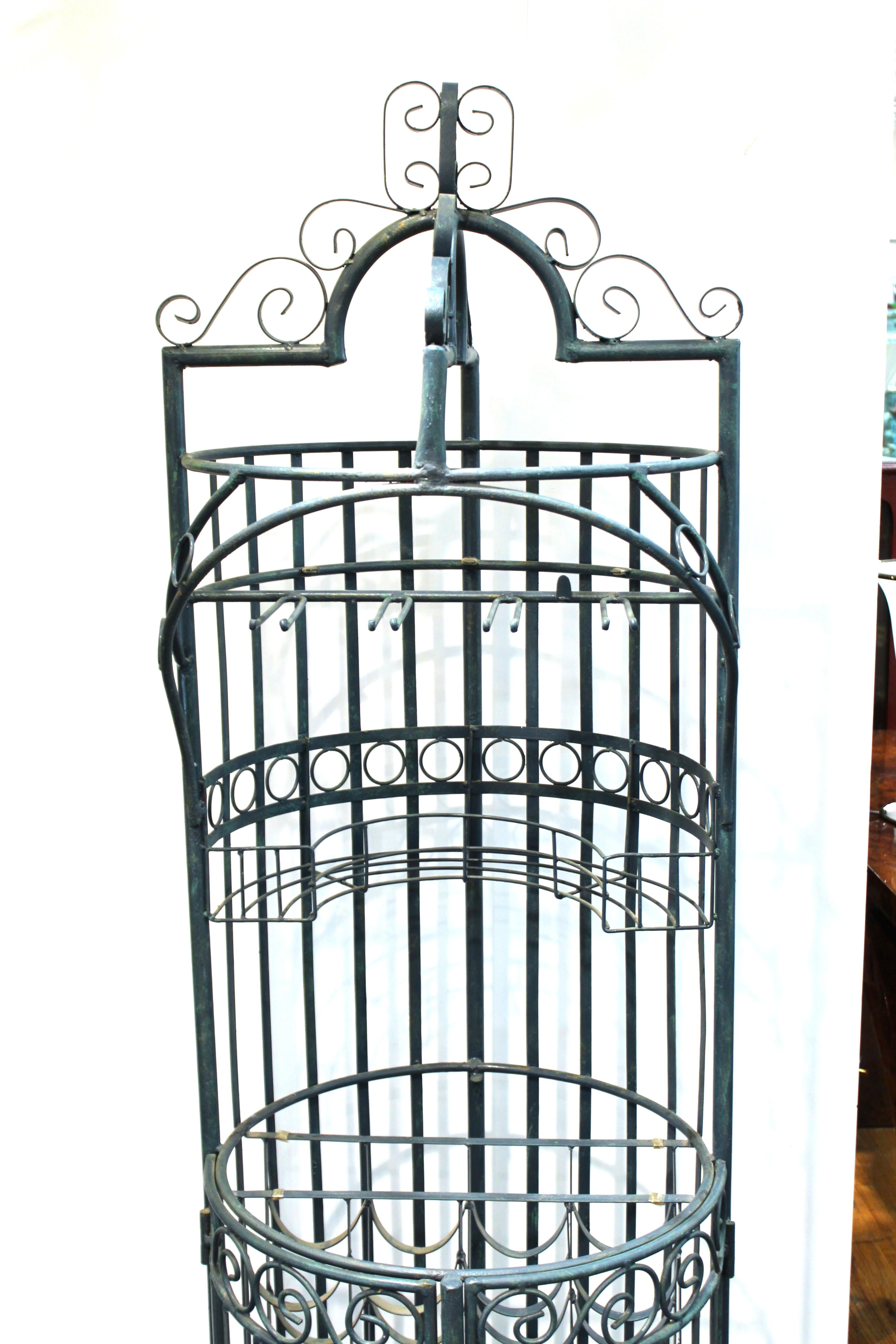 Mid-Century Modern wine bar or wine cage made of wrought iron. The piece has hinged doors on the lower part for accessing the wine storage shelves. The piece is in great vintage condition with age-appropriate wear to the metal. Missing the original