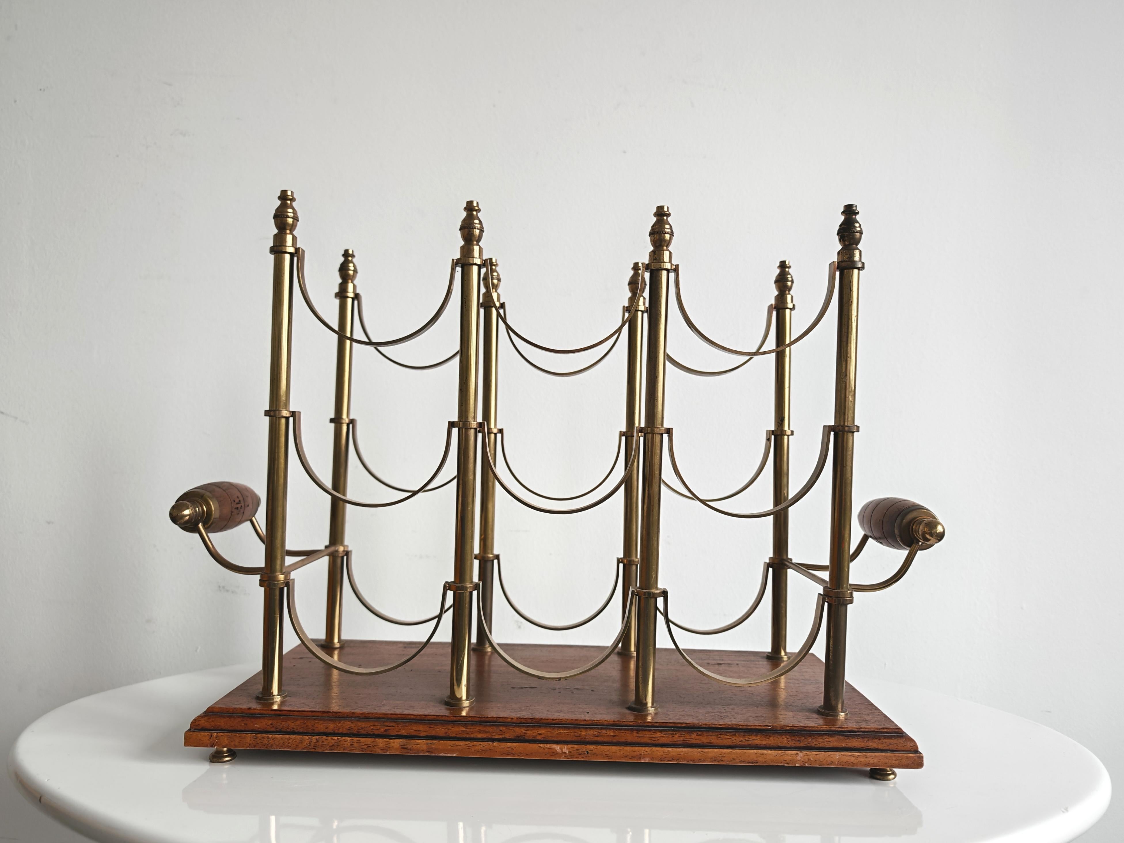 In questa inserzione troverai uno splendido e lussuoso portabottiglie da vino in ottone e mogano. Presenta un design di metà secolo, spesso associato agli stili Hollywood Regency o Neoclassico. Ha una capacità di contenere 9 bottiglie di dimensioni