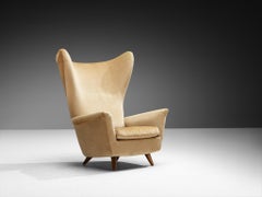 Sillón de respaldo alto de estilo «Mid-Century Modern» en madera de cerezo y tela beige, de los años 50