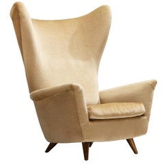 Sillón de respaldo alto de estilo «Mid-Century Modern» en madera de cerezo y tela beige, de los años 50