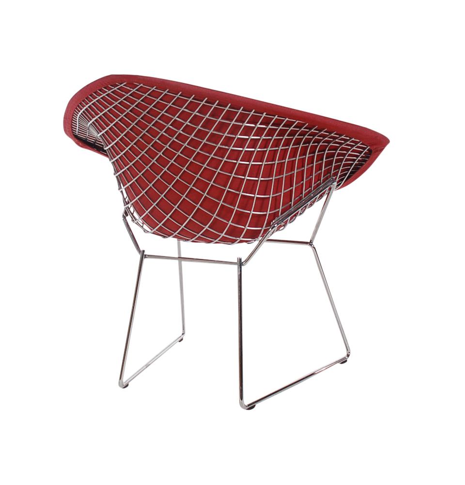 An iconic Classic designed by Harry Bertoia and produced by Knoll. This model features a chrome-plated steel frame with red fabric cover. Knoll label present on chair frame.