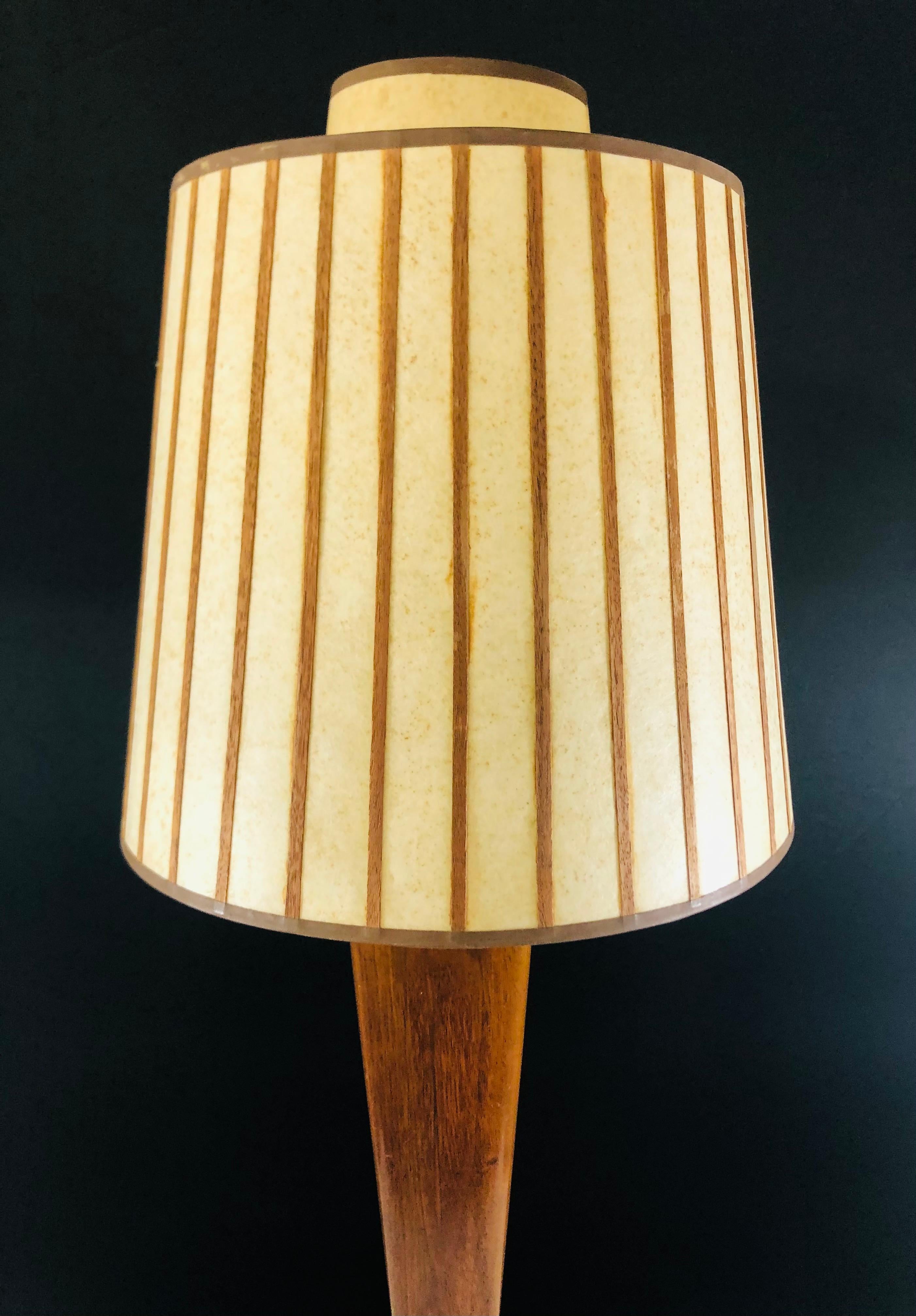 A stylish Mid-Century Modern wood lamp with a brass base. The lamp shade is handmade in a tan and brown color and the overall design of the table lamp is delightful and will add style to any living space. 

Measures: Lamp 35