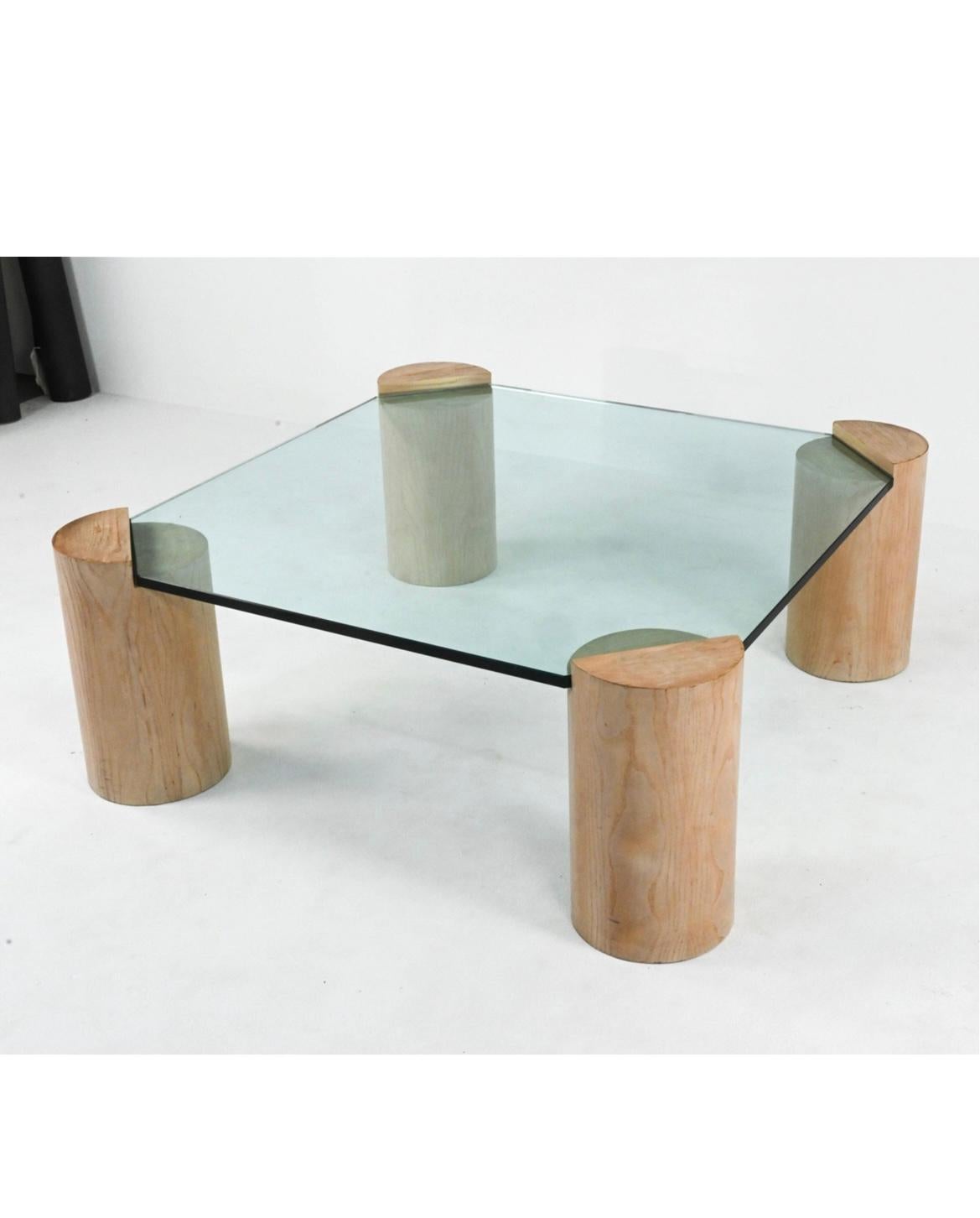 Mid-Century Modern sculptural coffee table with cylindrical wood legs and thick tempered glass top in the style of Karl Springer. C. 1980. Located in NYC.

Dimensions: H 17