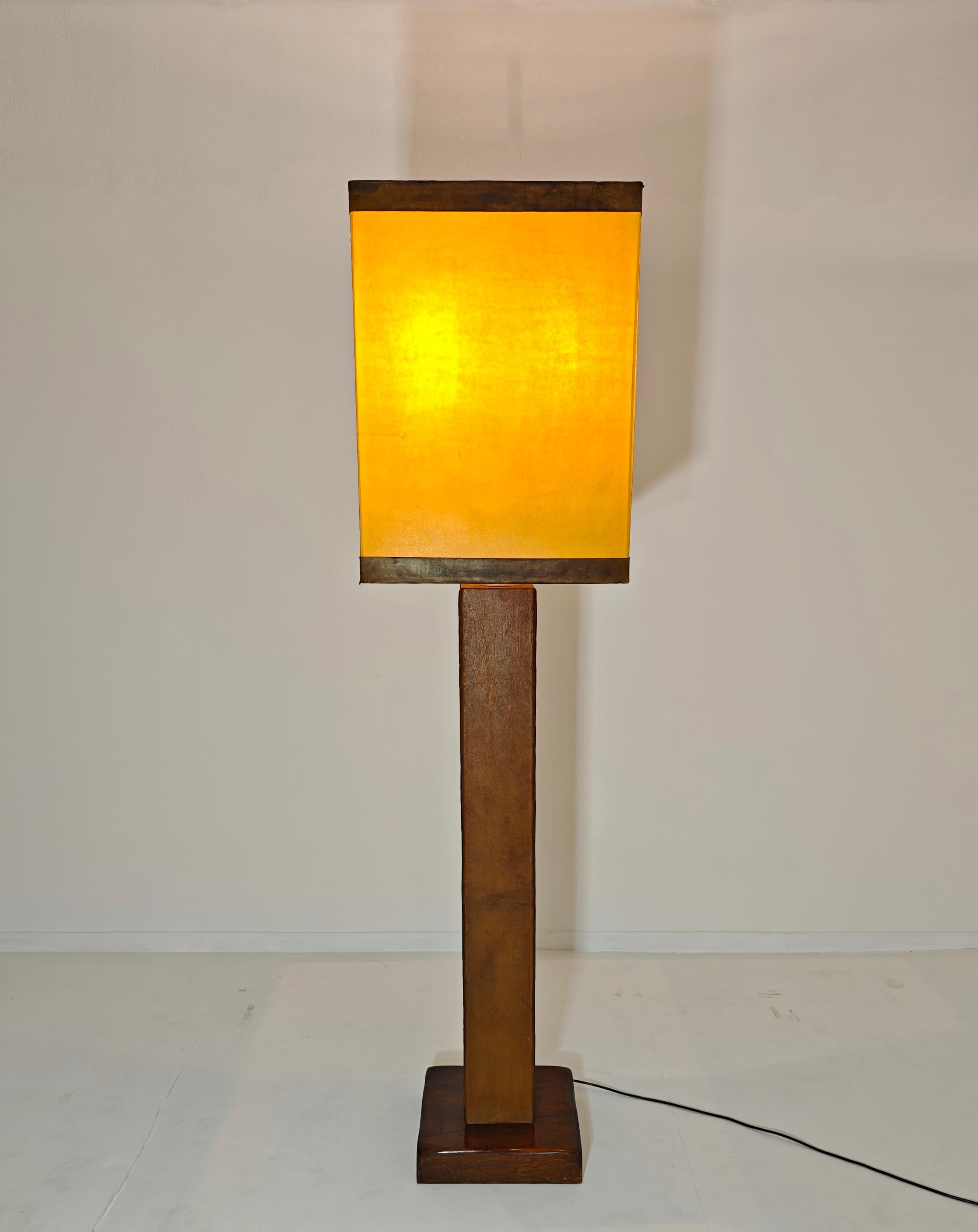 Grande lampada da terra a tre luci. Base in Wood Wood. Albero centrale rivestito in pelle. Paralume grande con bordo in pelle. All'interno, un secondo paralume centrale in alluminio per dirigere la luce verso l'alto. Alle estremità sono posizionate