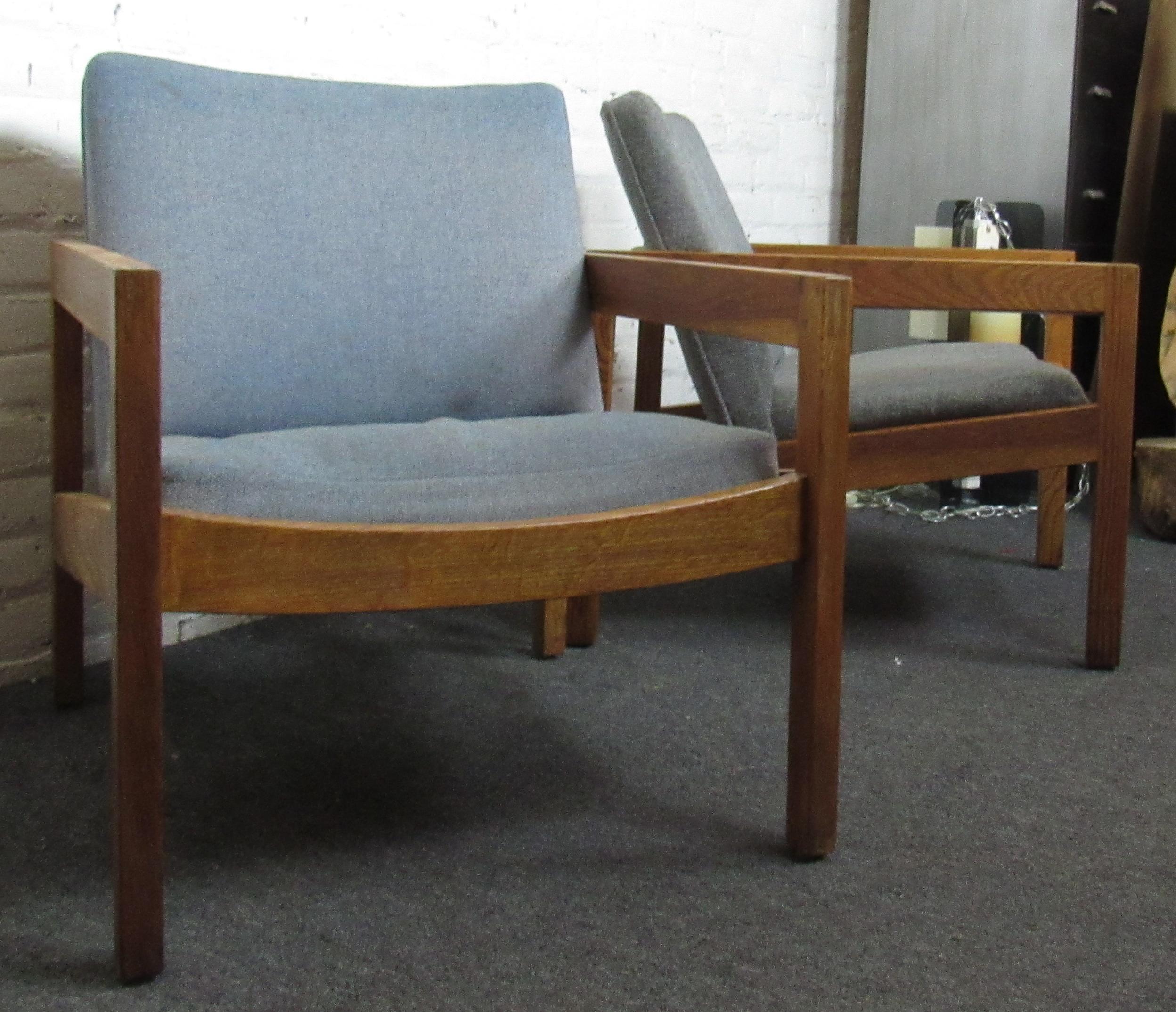 Beautiful set of two vintage modern baby blue lounge chairs. The chairs sit on a frame of richly stained wood with beautifully notched joints. These supremely comfortable lounge chairs, perfect for reading or having a relaxing morning coffee would