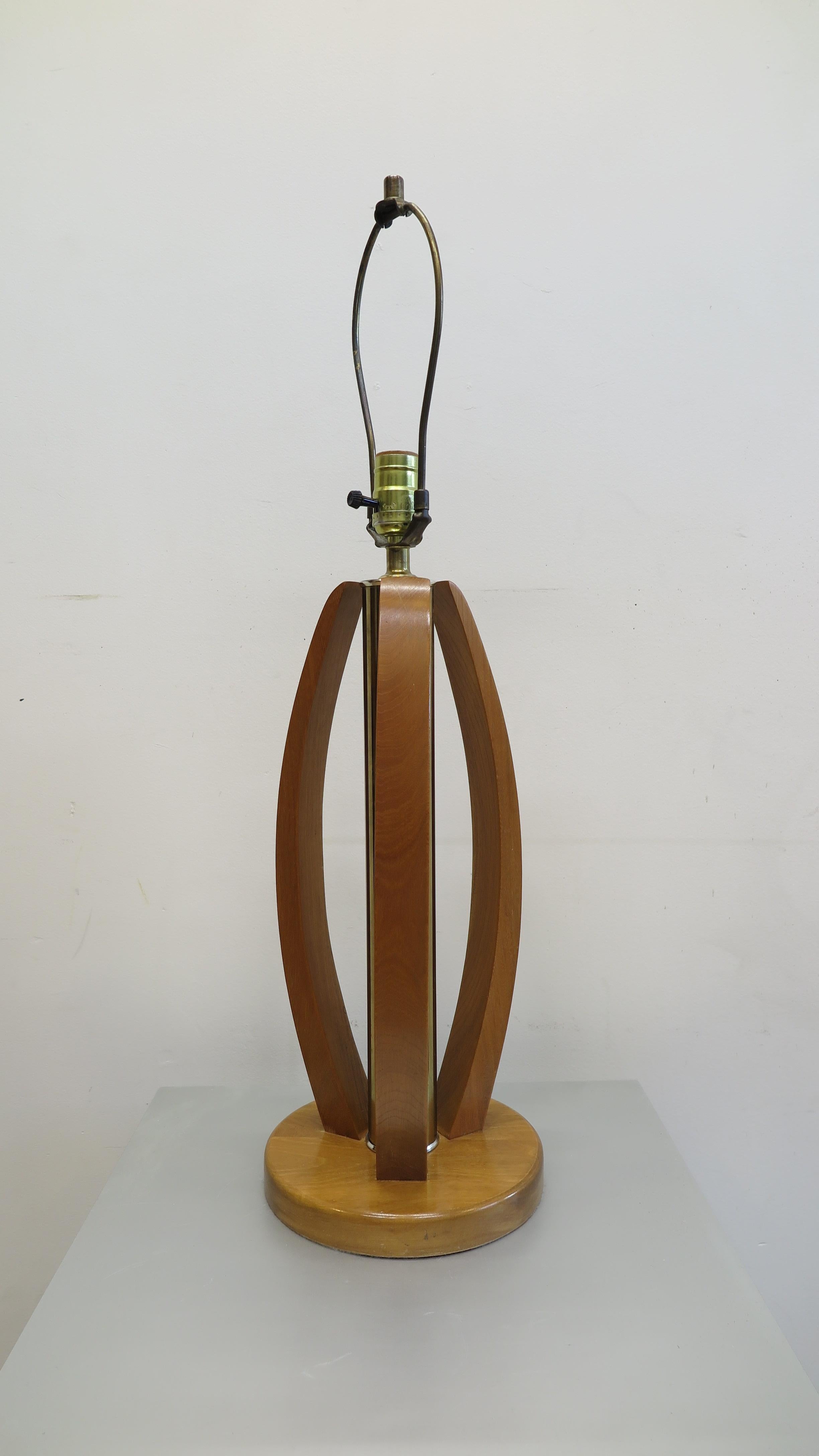 Mid-Century Modern brass & wood table lamp. Three sculpted wood surrounds with brass column mid century modern table lamp. In good condition operating with a three way switch. American 1970. The listing is for 1 lamp. We have a pair available. 

 