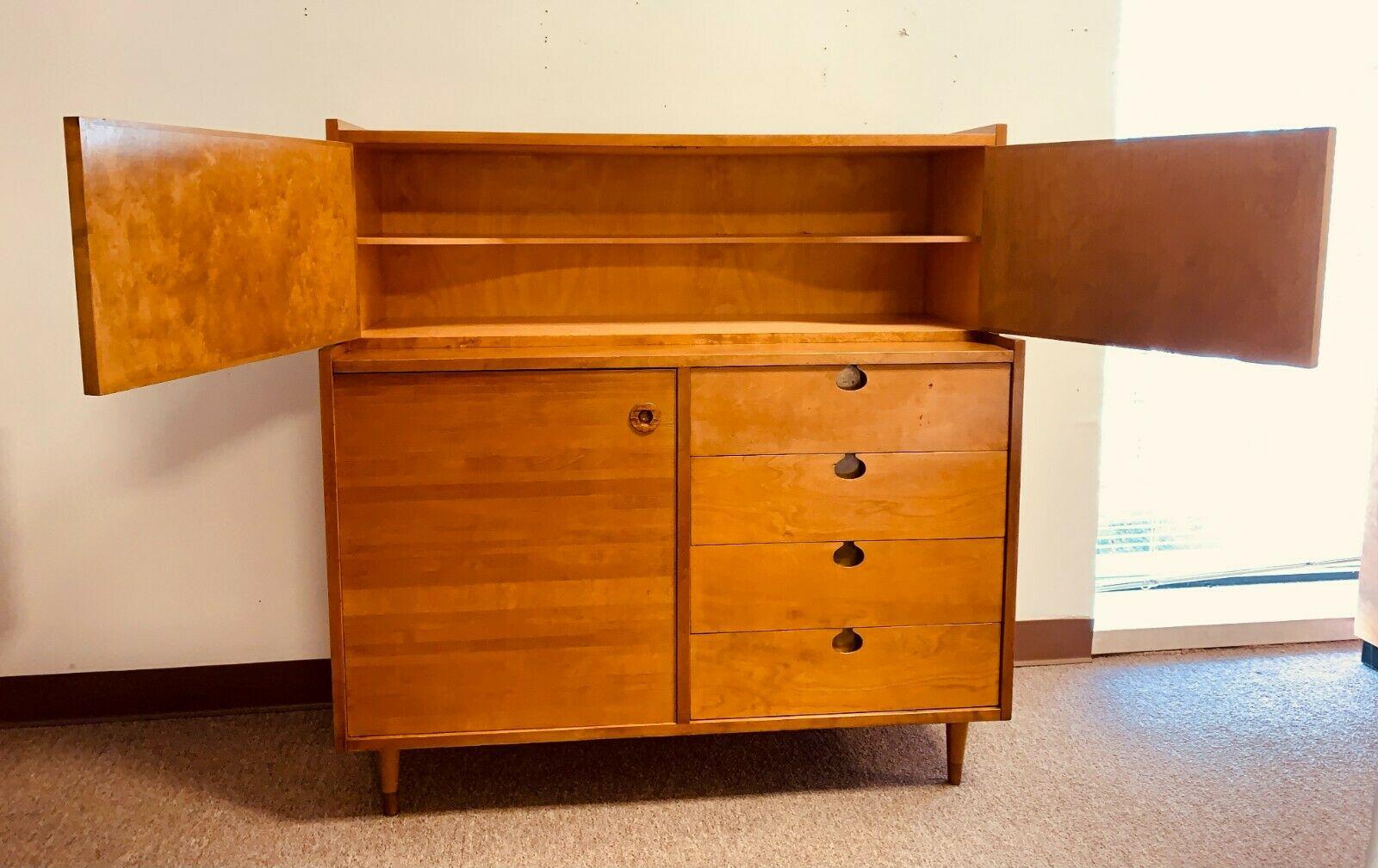 A fantastic high boy dresser, perfect for organization or bedroom storage. This piece includes 4 pull-out drawers along side a 3 enclosed shelves. The top storage includes one shelf which runs the length of the dresser. In good vintage condition,