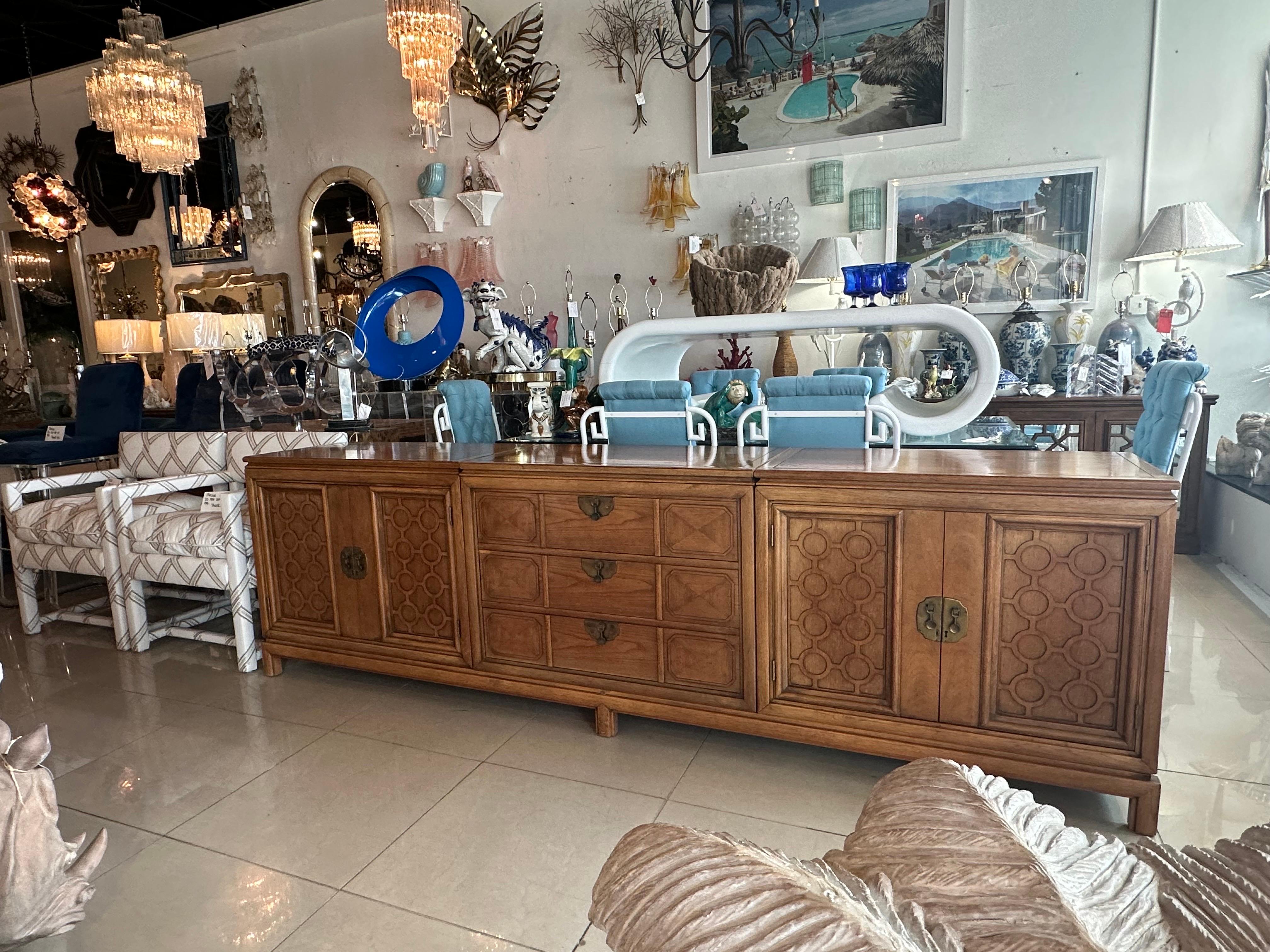 Beautiful vintage 1960s wood and brass credenza, buffet, sideboard, dresser by Thomasville Tamerlane. Double doored cabinets on both ends with shelf inside. Middle is 3 drawers. Each piece sits on the ming style modern base. This cabinet is finished