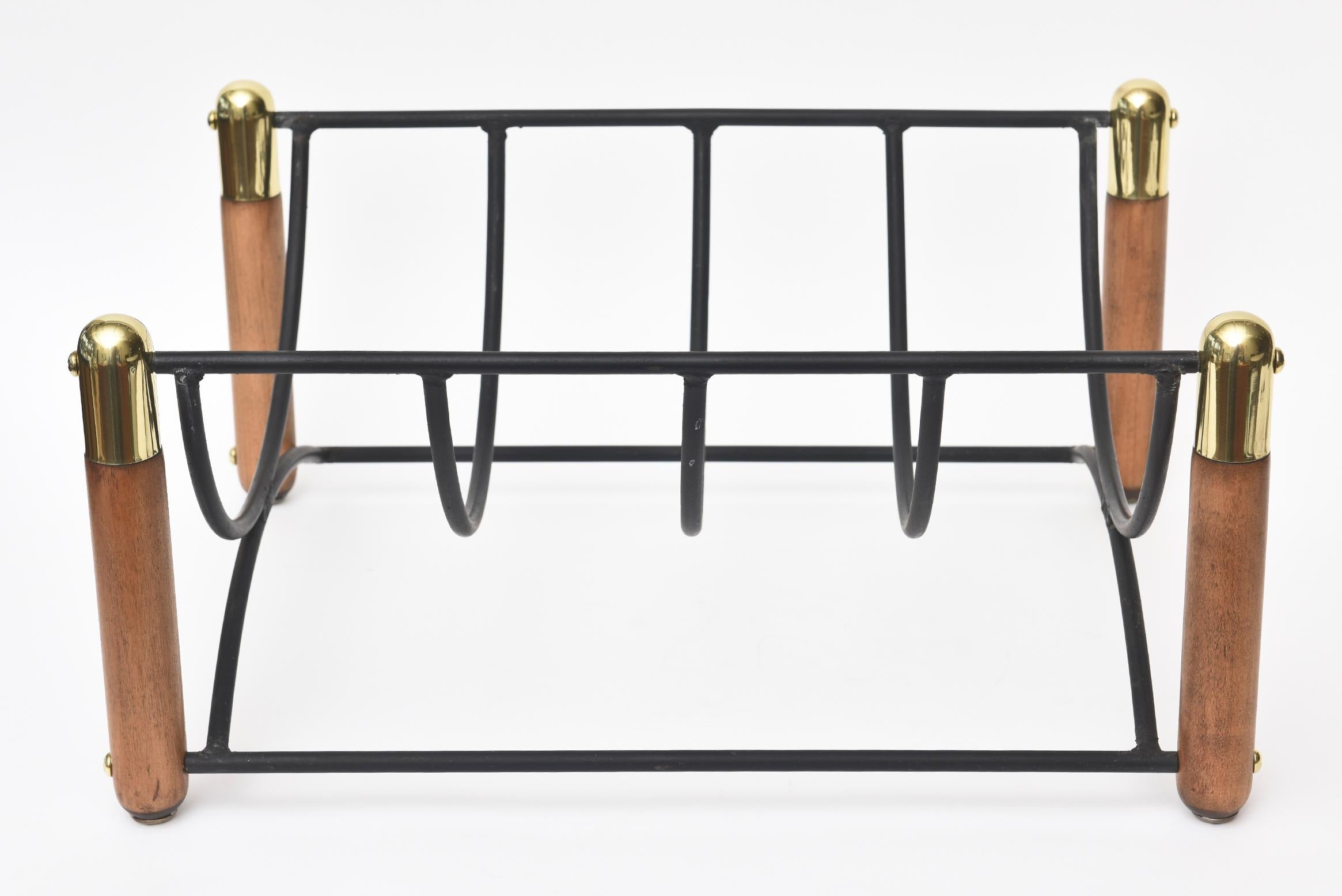 This Mid-Century Modern vintage brass, wood and black iron magazine stand or rack and or log carrier for a fireplace is handsome and very utilitarian. it serves as a Dual purpose for logs or magazines. The brass has been polished and the wood was