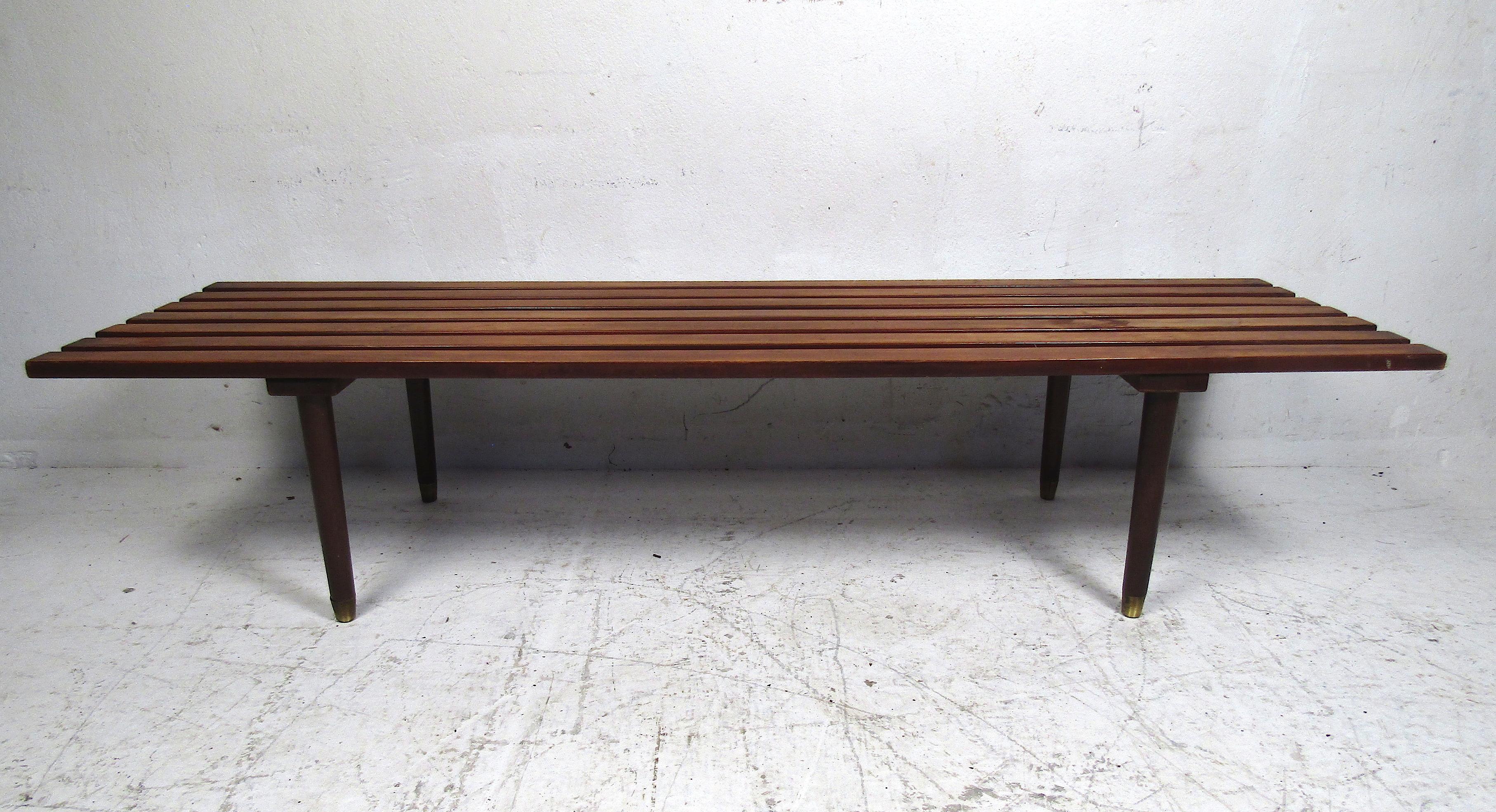 Stylish midcentury slat bench or coffee table. Walnut finish, with tapered legs and brass sabots capping the feet. This would make a nice addition to any modern interior. Please confirm item location with dealer (NJ or NY).