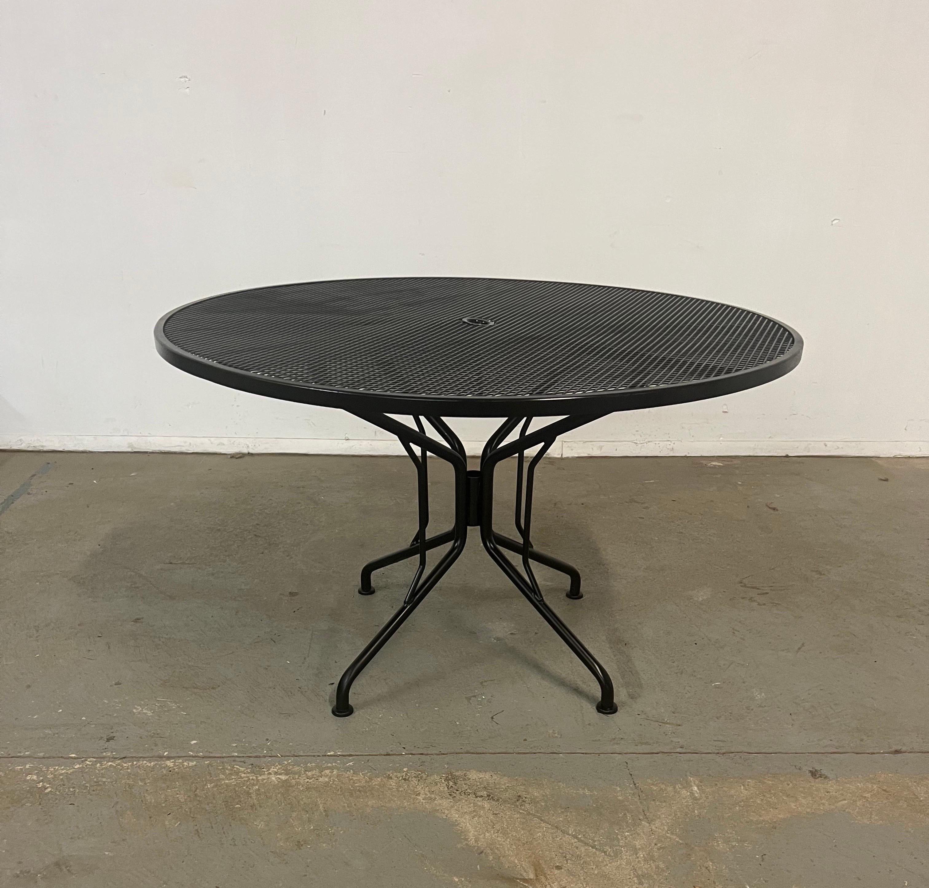 Mid-century outdoor iron woodard round dining table 
Offered is a mid-century outdoor iron woodard round dining table. Features black paint and woven wrought iron. The table is structurally sound in good condition and can accommodate up to 4 seats.