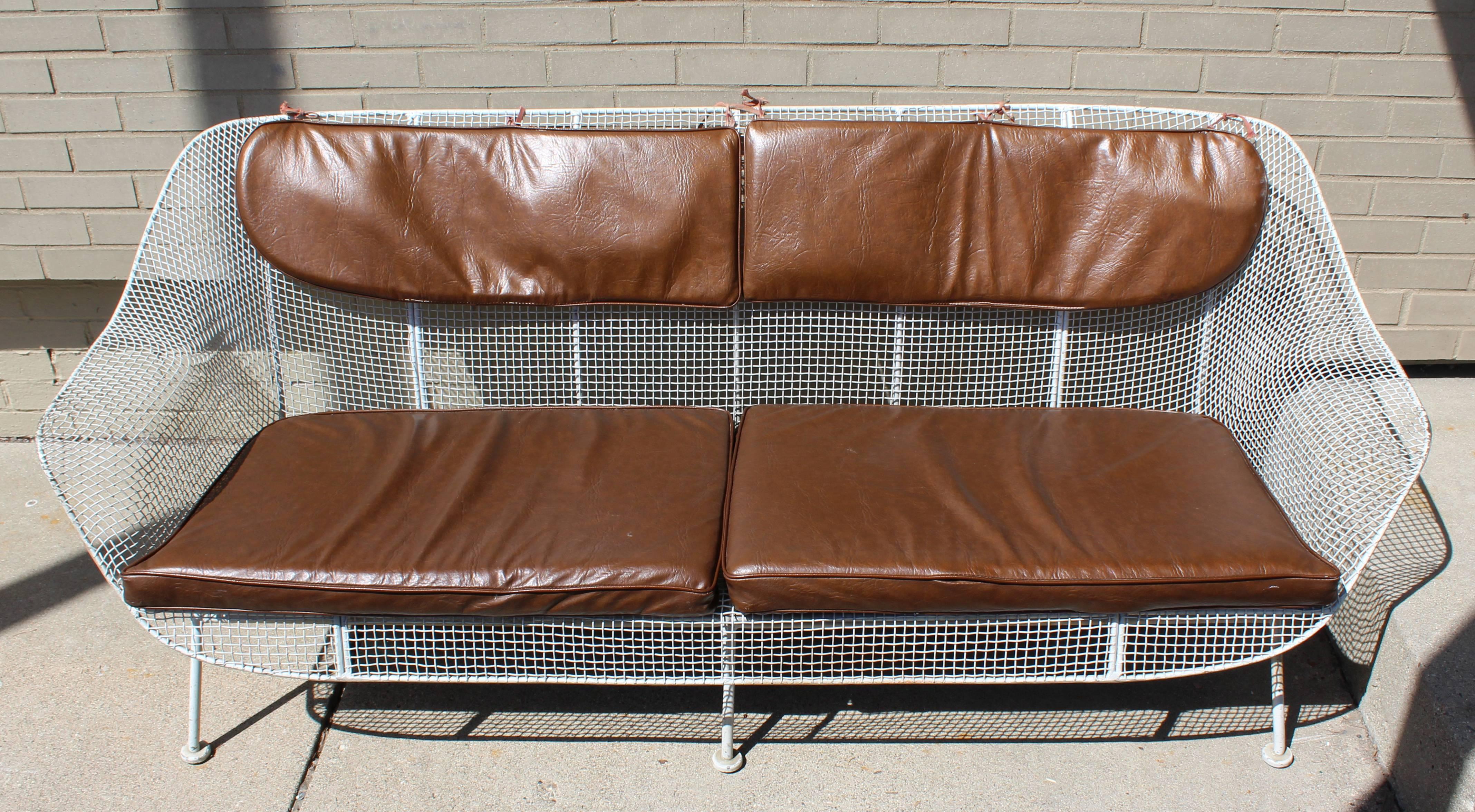 For your consideration is an incredible wrought iron, patio sofa, with rare pads made of brown vinyl, by Woodard, circa 1950s. In great condition. The dimensions are 72.75