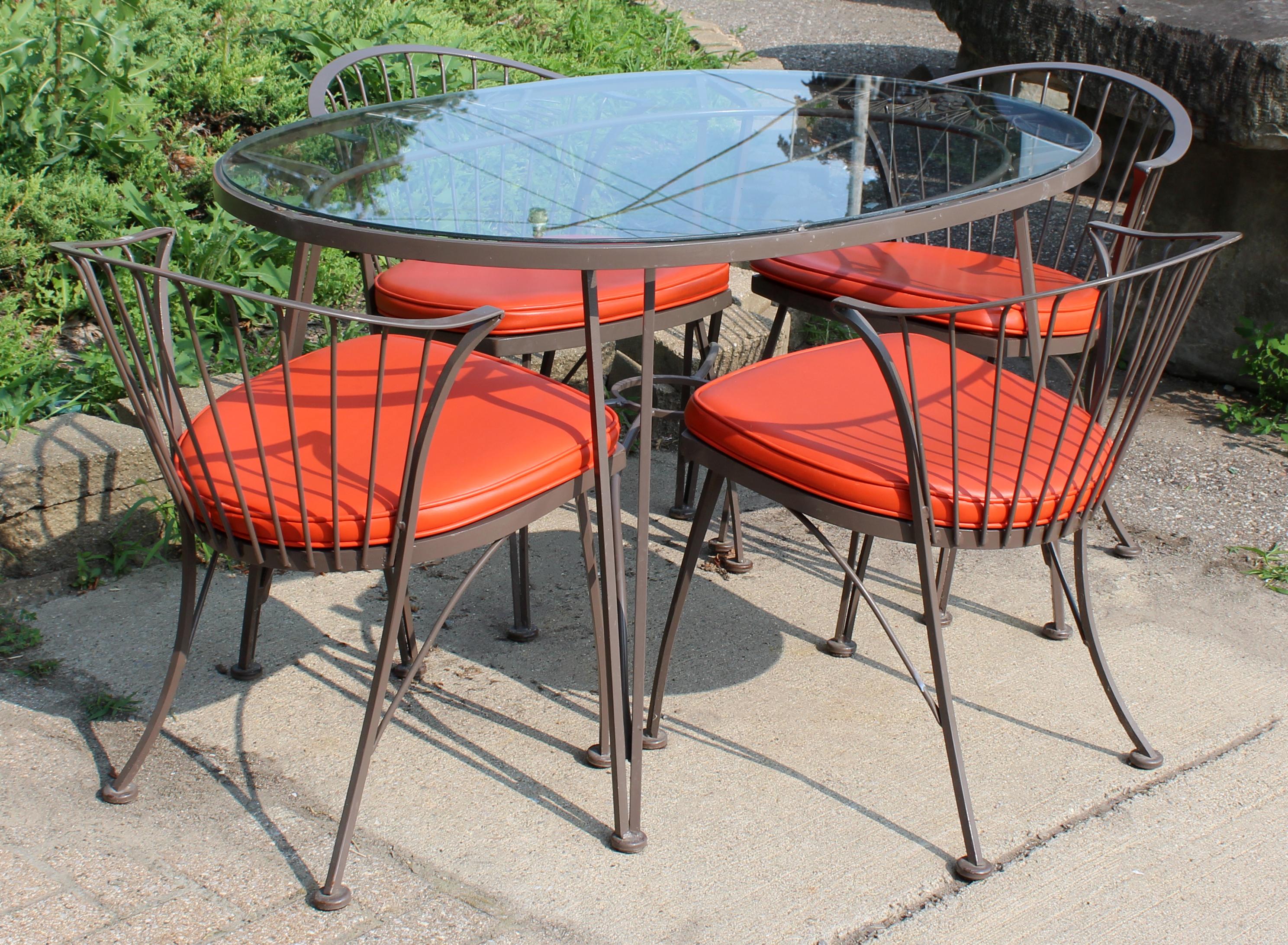For your consideration is a rare full Klismos patio set, including four chairs with orange seat cushions and a pinecrest table with a glass top, by Russell Woodard, circa the 1960s. In very good vintage condition. The dimensions of the table are 52
