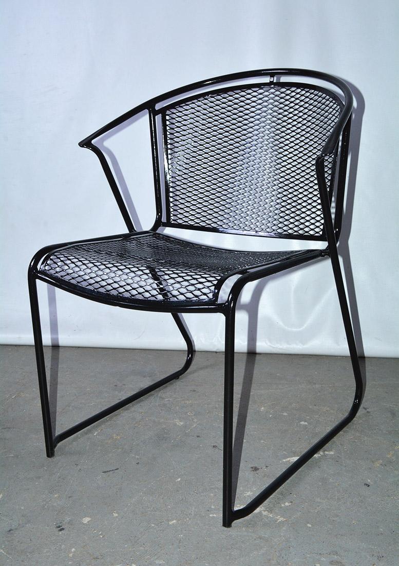 Stackable set of six Mid-Century Modern Woodard style wrought iron barrel back arm chairs, classic contoured diamond mesh surface. These garden chairs are painted black. For indoor or outdoor use. Metal garden/patio/or porch lounging or dining