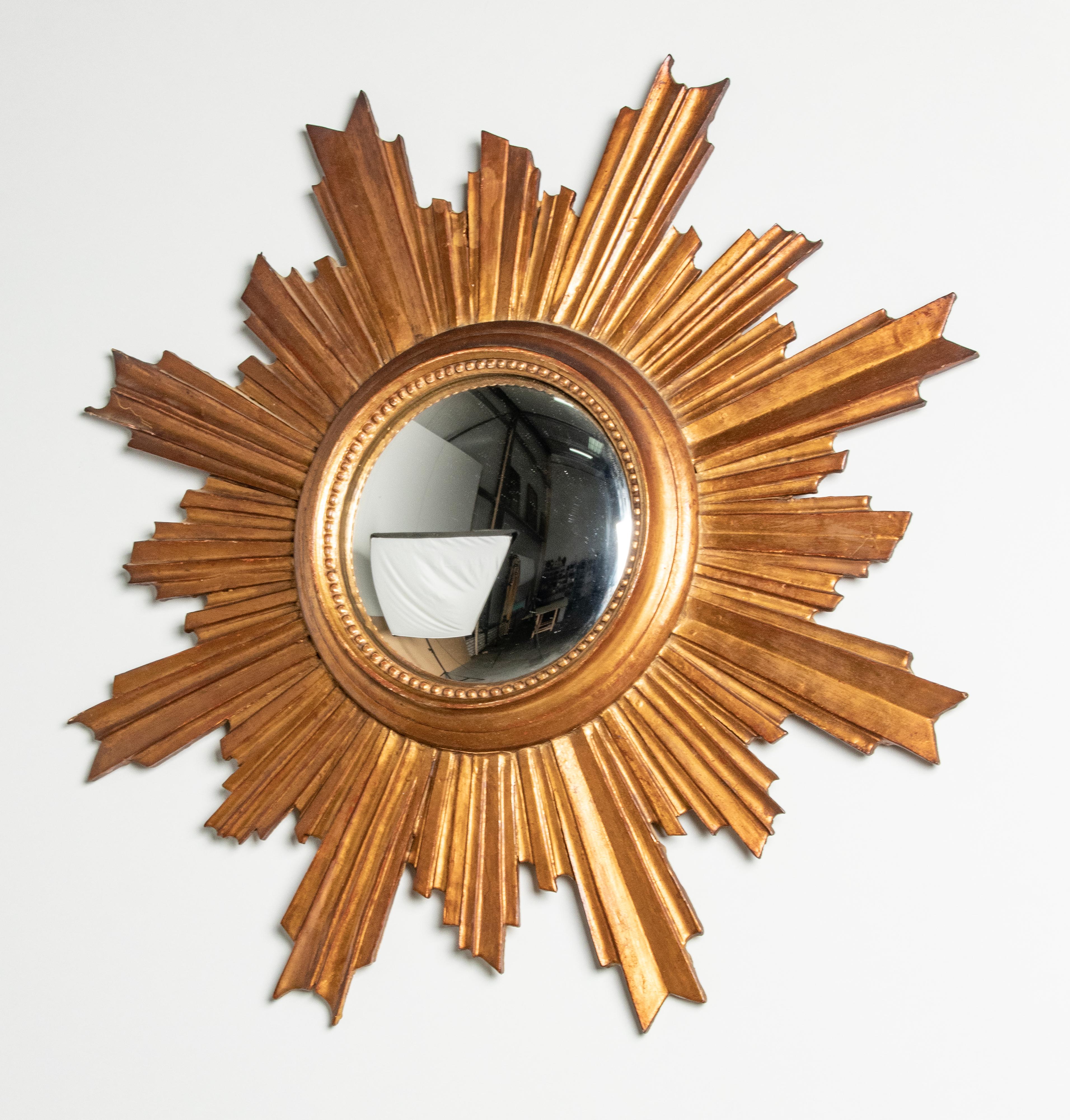 Beautiful gold-plated sunburst mirror. Dating from circa 1960, presumably of Italian manufacture. The mirror is made of wood, beautifully sculpted. With convex glass mirror. In good condition.