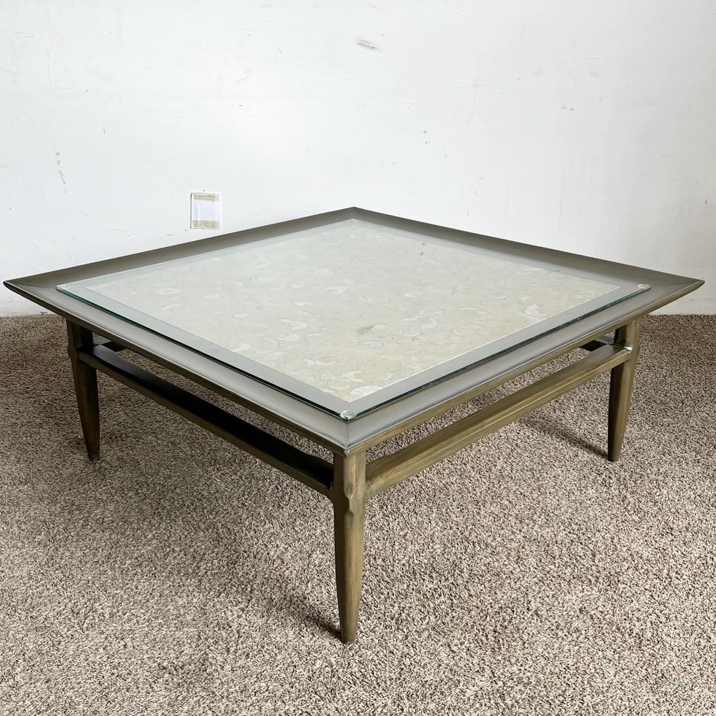 The Mid Century Modern Wooden Square Coffee Table, with its exquisite Portuguese marble inlay top, offers a blend of luxury and mid-century style. The sturdy wooden base complements the unique marble patterns, creating an eye-catching centerpiece.