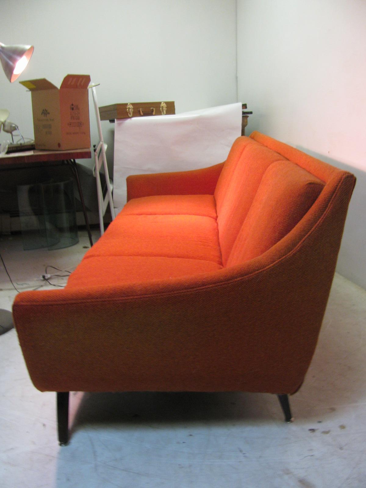 Fabulous 3-seat wool tweed sofa by Bassett. Solid frame and great form in a mid sixties orange. Cushions show a little wear but the foam is still springy. No stains tears or odors. Two lounge chairs with an ottoman in a another listing.