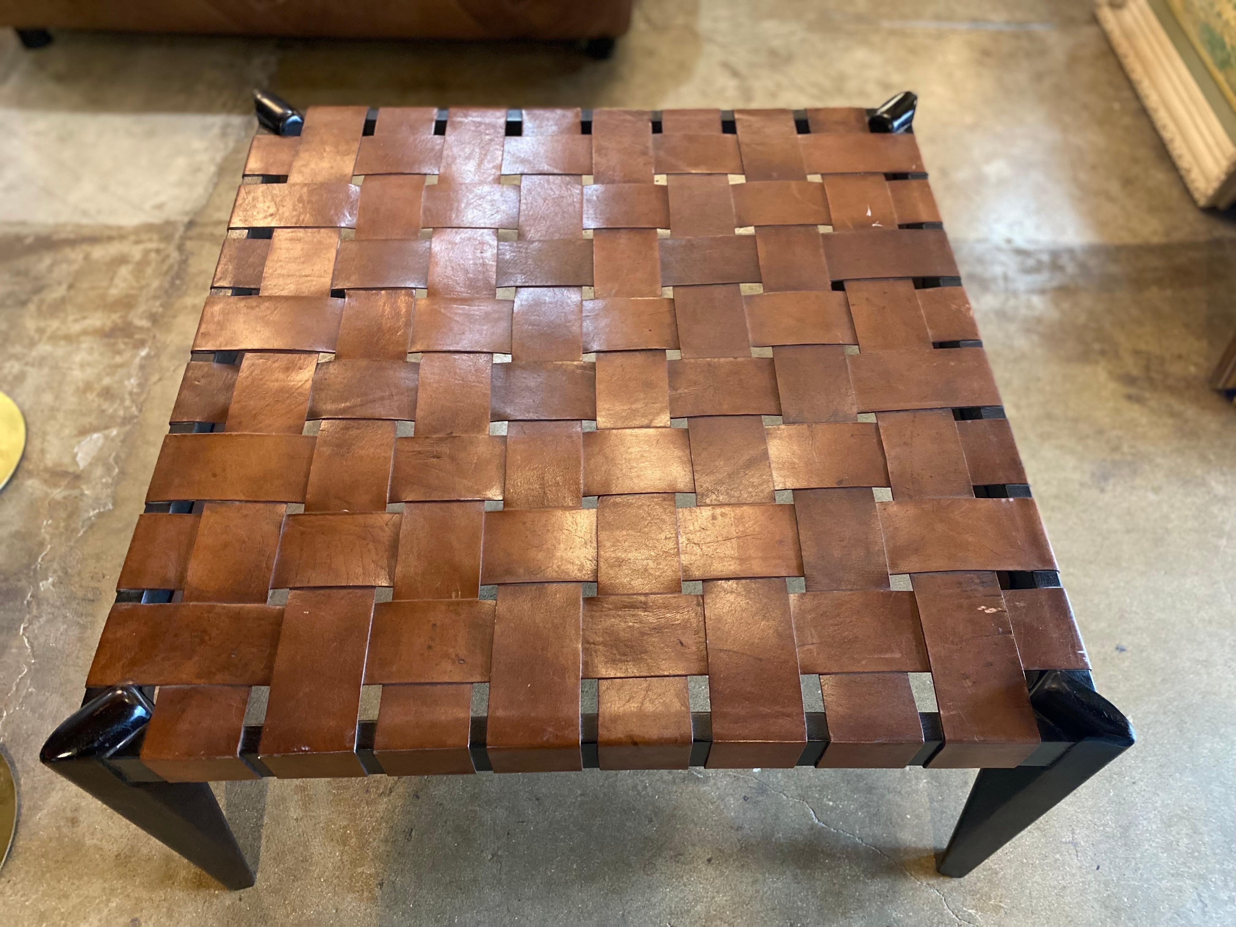 Beautiful midcentury table in the manner of Edmond Spence features a woven leather top with a mahogany base. This coffee or accent table is in good condition. Dimensions: 34