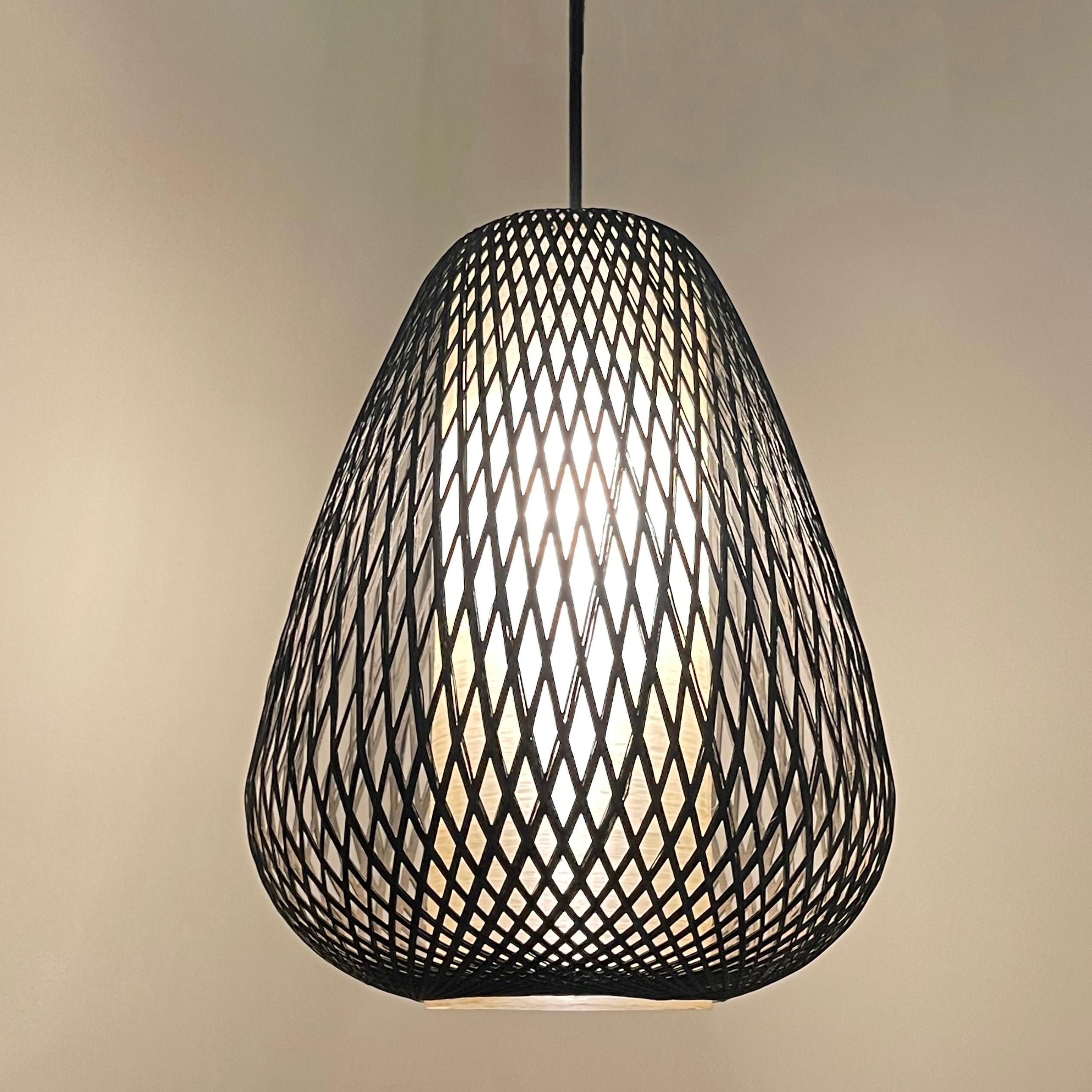 Mid century modern pendant light features a woven, gourd shape exterior with translucent fiberglass cylinder diffuser. The pendant is newly wired with 50 inches of black cloth cord to hang at an overal height of 69 inches.
 