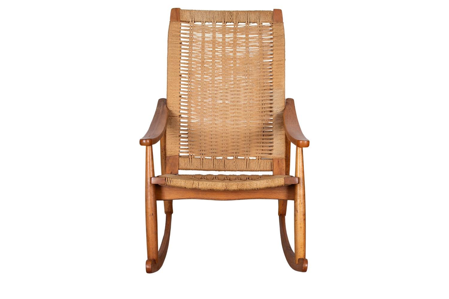 Sedia a dondolo in corda intrecciata della metà del secolo scorso nello stile di Hans Wegner. Presenta un elegante schienale e una seduta a corde, allungati su una struttura in Wood. Una sedia comoda con bracciolo curvo.  Il bellissimo intreccio di