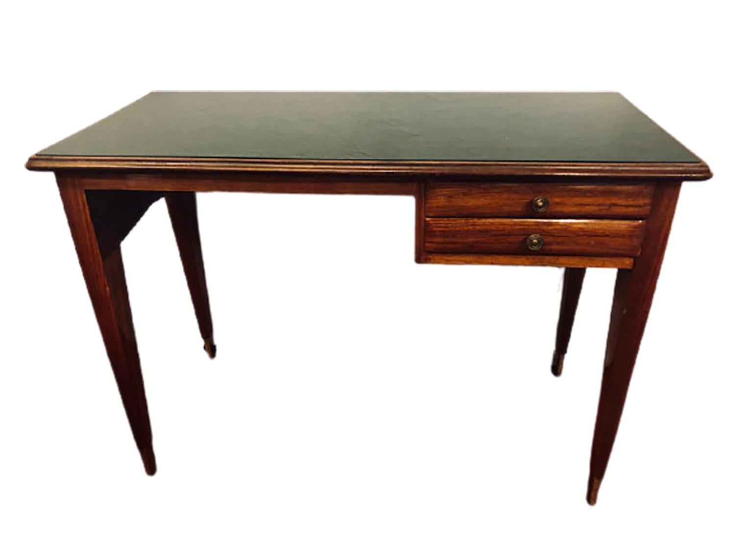 Mid-Century Modern writing table in rosewood with a green glass top having two drawers and a knee hole opening this vanity or writing desk is a nice size to fit in most homes. The whole sits on bronze sabots and has recently been polished.