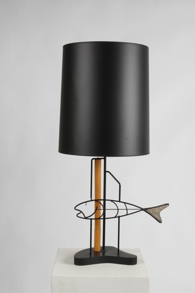 Mid-Century Modern Frederic Weinberg style black wrought iron fish lamp, with fiberglass tail that resembles scales, with bamboo support & final on wood biomorphic base. Excludes black shade. Very nice condition, minor wear. Shade shown is 16