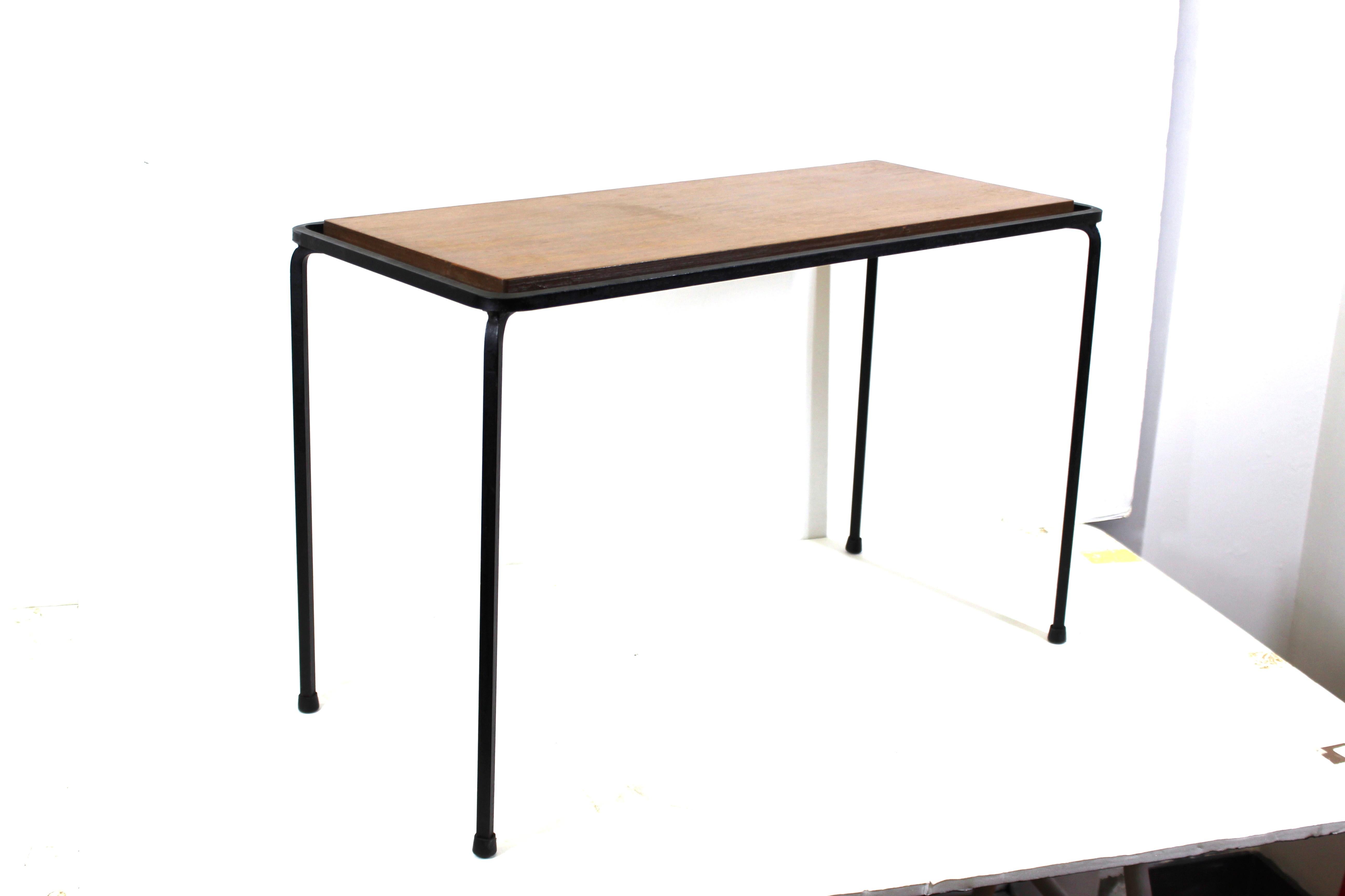 Mid-Century Modern diminutive rectangular side table with wrought iron structure and wood top.