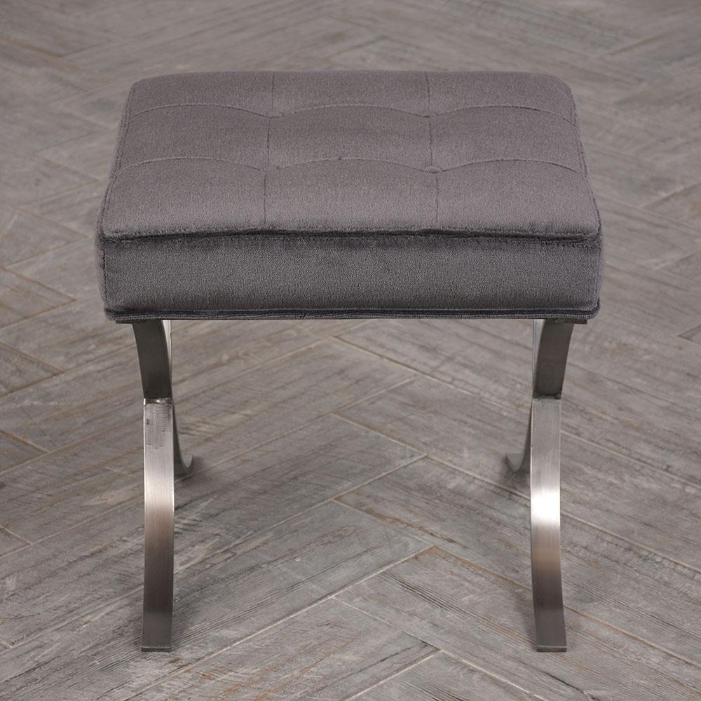 The 1960s Mid-Century Modern style bench features a chrome base and upholstered seat. The chrome base is X-shaped and very sturdy. The seat has been professionally re-upholstered in a dark grey mohair velvet fabric with tufted and top stitch