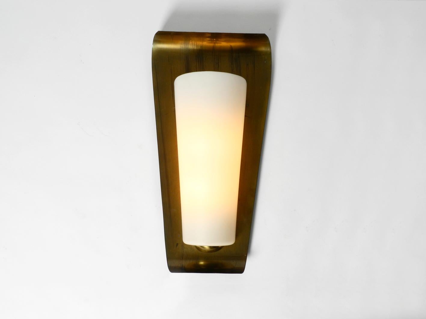 Extremely rare elegant extra large Mid-Century Modern wall sconce by Wilhelm Wagenfeld. Made by Peill & Putzler in the 1950s. These lamps were produced for churches. Nice detailed 1950s design.
Glass shade made of satin finish glass with original