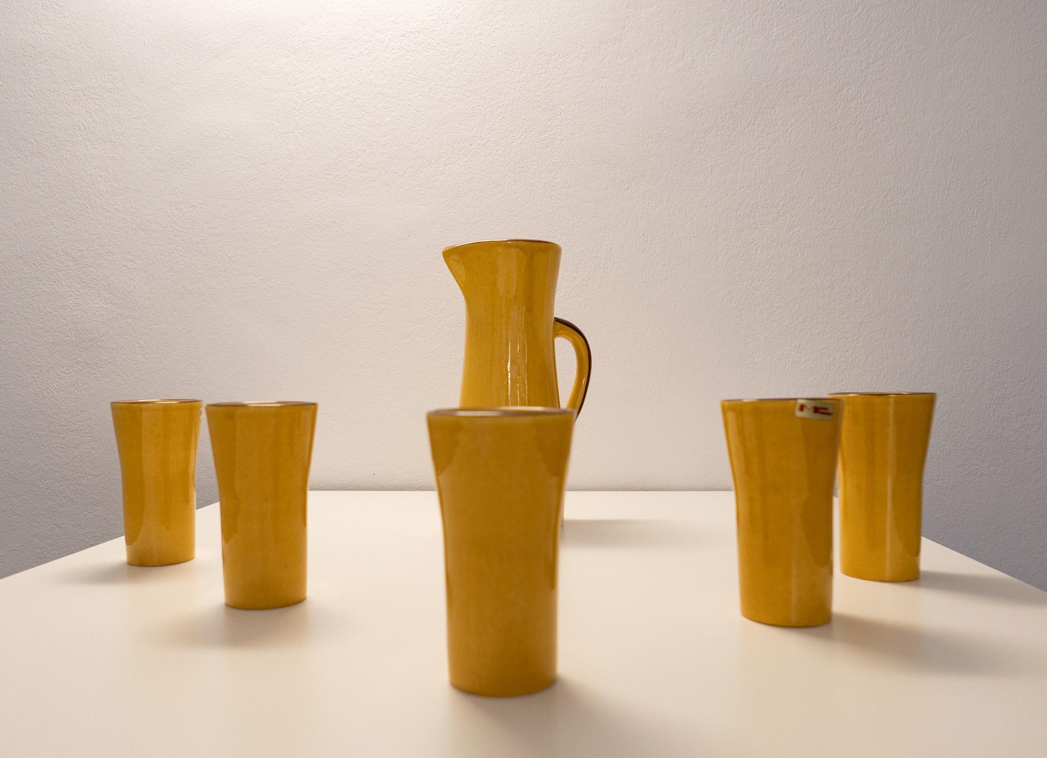 Mid-Century Modern yellow carafe set with 5 Mugs in Glazed Ceramic, France 1970s.

Lovely French Carafe Set with 5 Mugs in wonderful glazed ceramic, signed mc, from the 70s. This kind of glazed ceramique is called Faience, or tin-glazed and