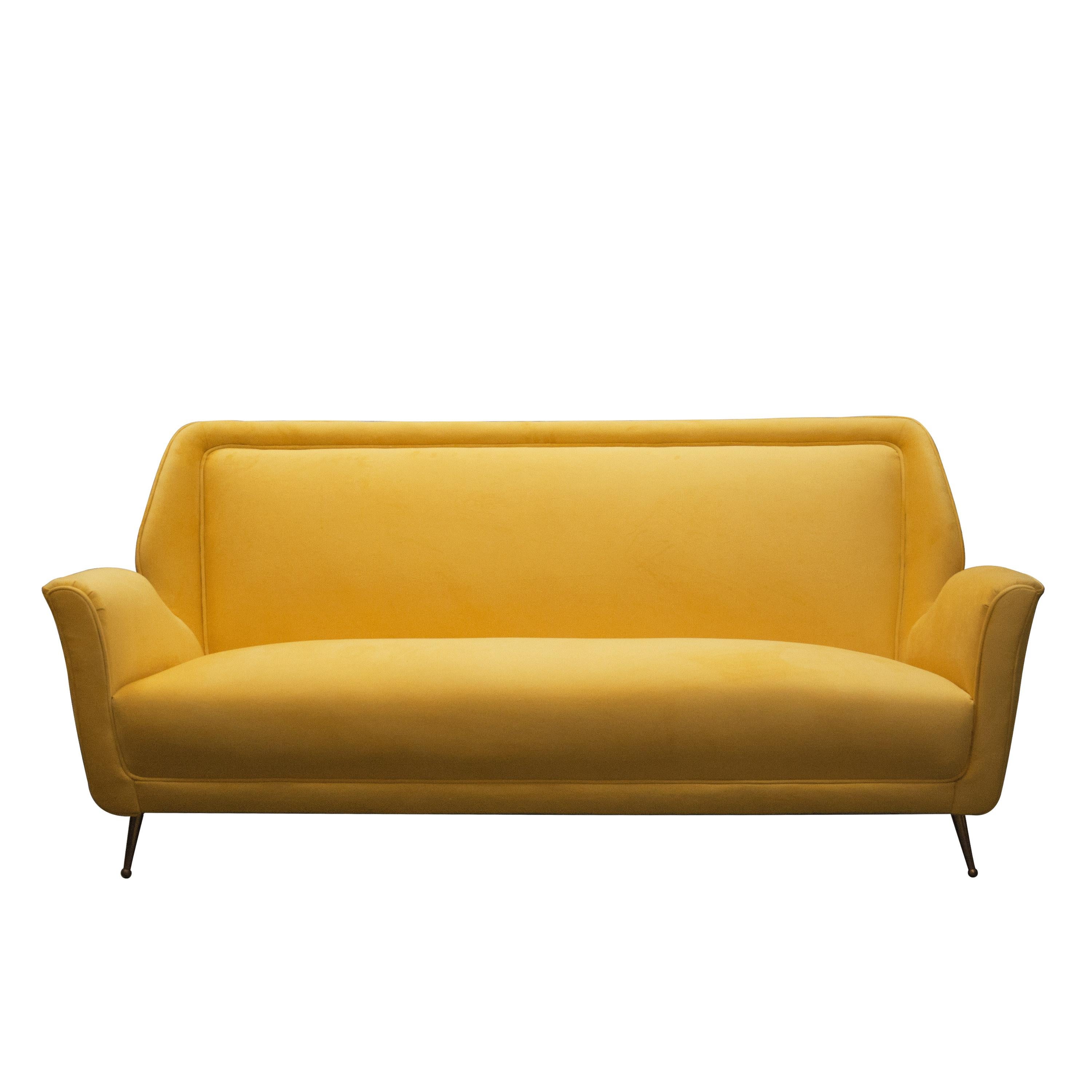 Mid-Century Modern three-seating sofa. Made of solid wood structure and polished brass legs. Upholstered in light yellow cotton velvet.