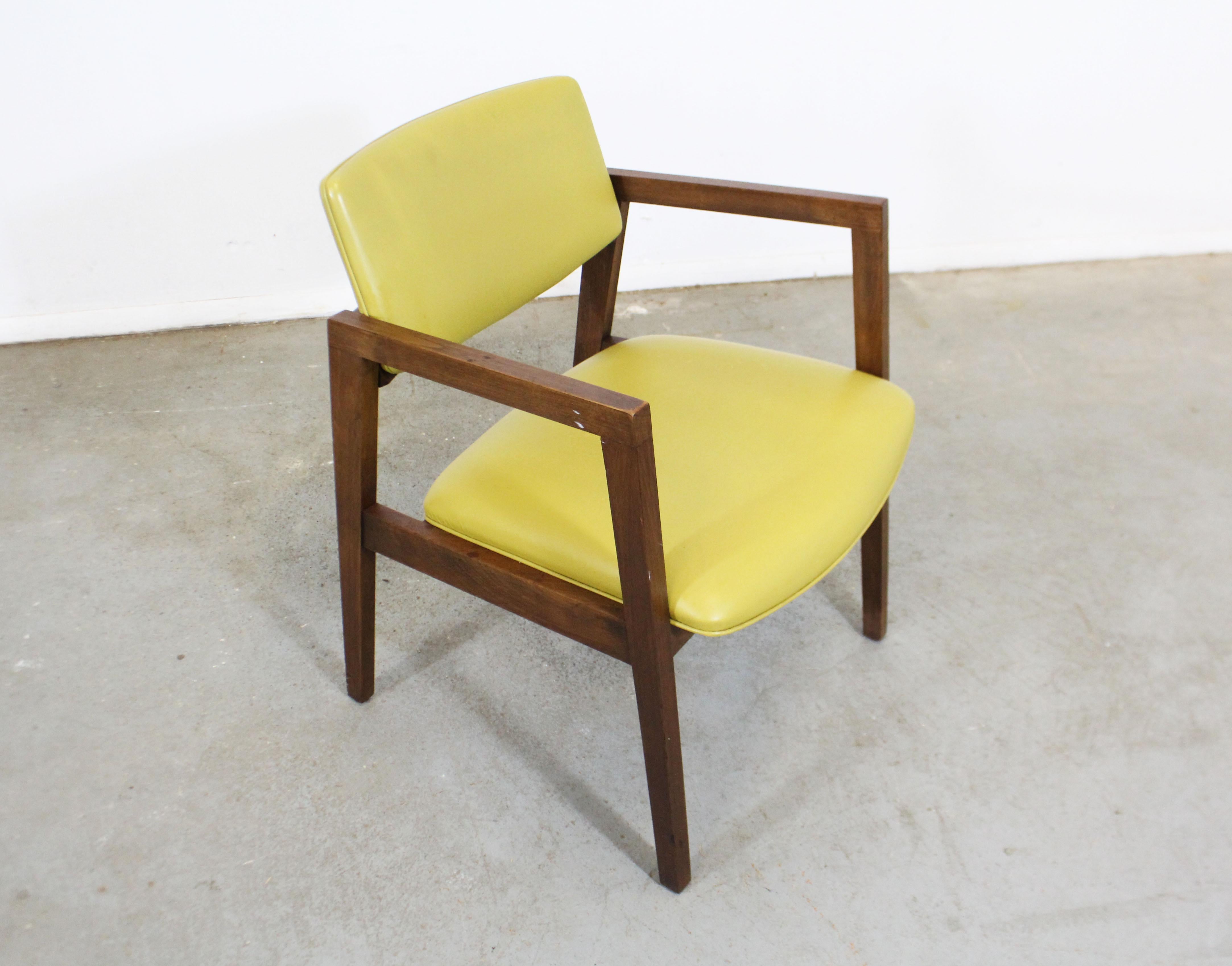 Offered is a Classic Mid-Century Modern armchair with a walnut base and vinyl upholstery. Considering its age (circa 1960s), it is in decent condition, structurally sound, but has stains/wear on the vinyl and surface scratches/chips on the wood.