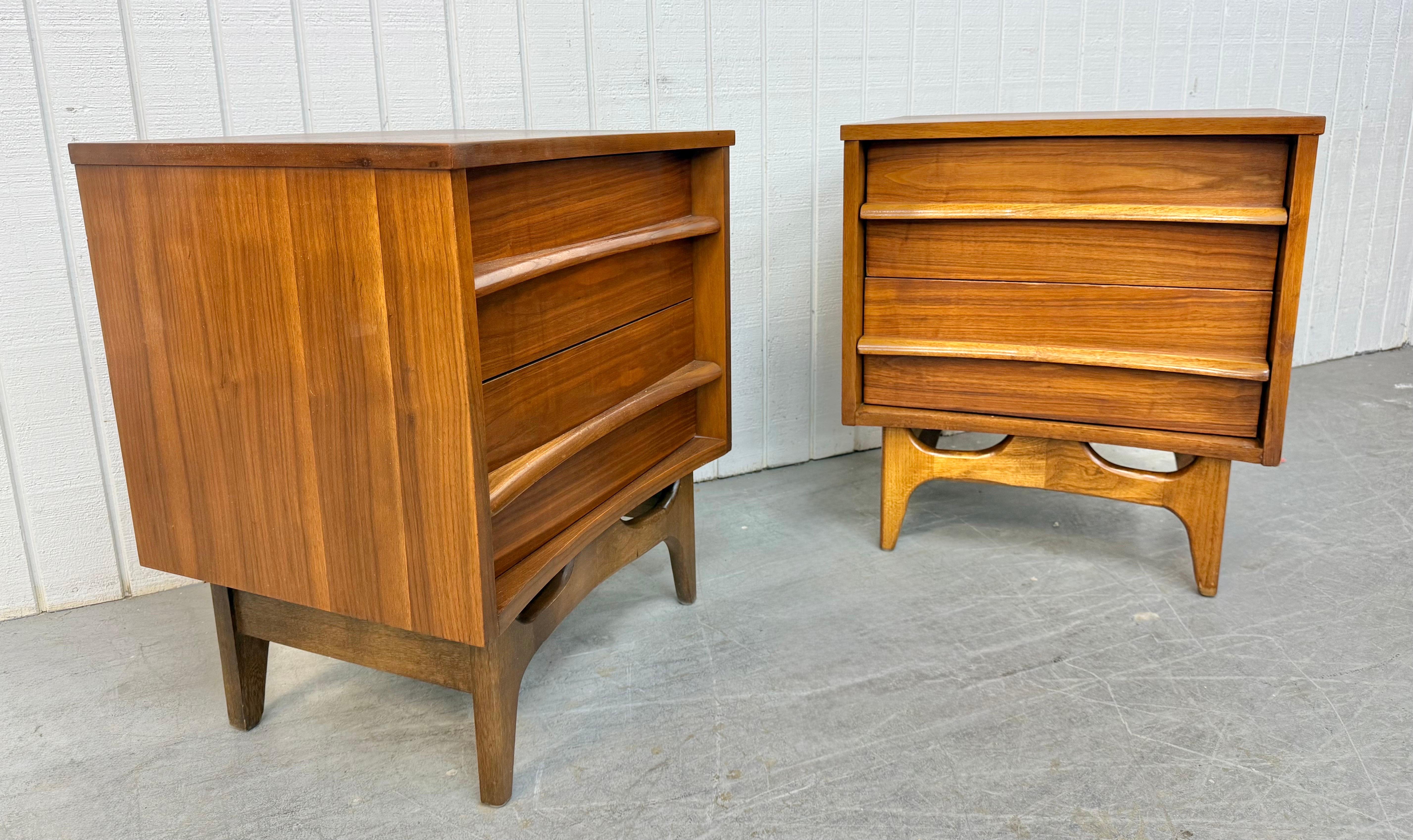 Questo annuncio si riferisce a una coppia di comodini in noce curvato della Young Manufacturing, di epoca moderna. Il design è caratterizzato da un frontale curvo, due cassetti con tiretti in legno, gambe moderne con base a tesa e una splendida