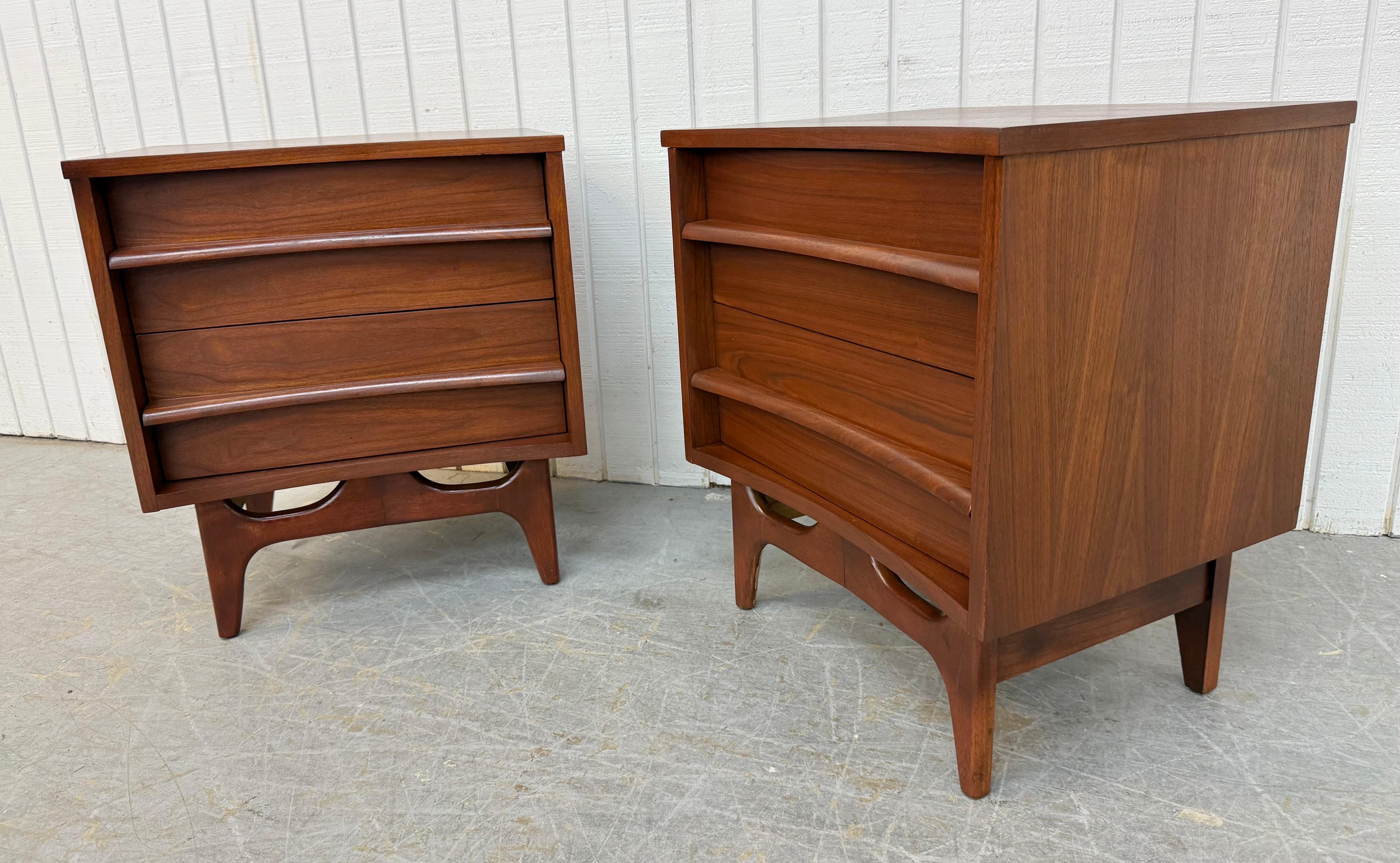 Cette annonce concerne une paire de tables de nuit en noyer de Young Manufacturing, de style moderne du milieu du siècle. Elle est dotée d'une façade incurvée, de deux tiroirs avec des poignées en bois, de pieds modernes et d'une magnifique finition