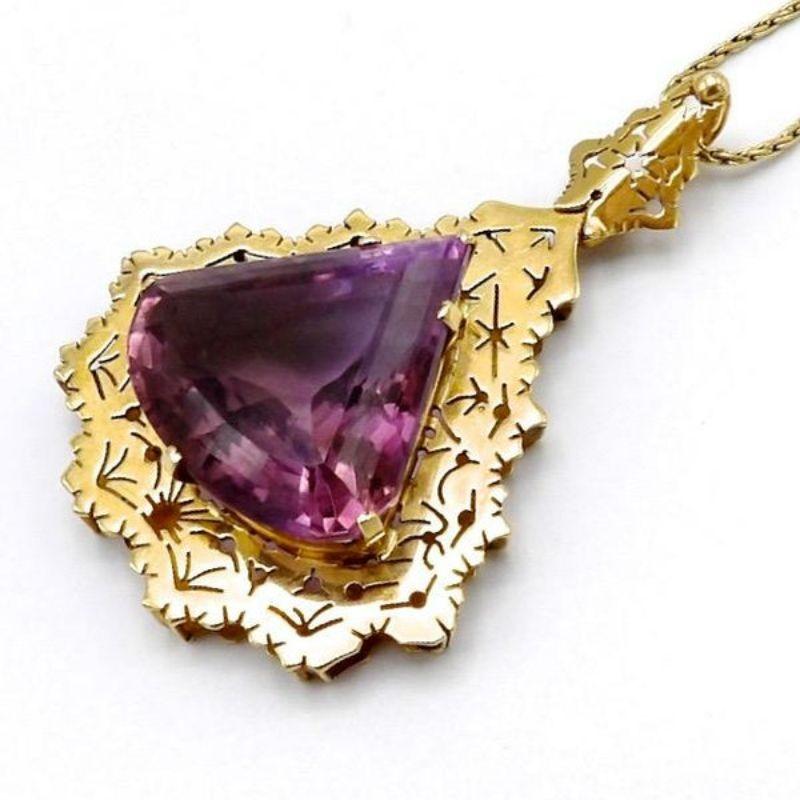 Uno splendido ciondolo modernista con gemma ametista incastonata nell'oro giallo 14k. Il ciondolo ha una forma a goccia triangolare, mentre i dettagli segati a mano danno un'impressione di fiocco di neve o di organico. Questo è un ottimo esempio di