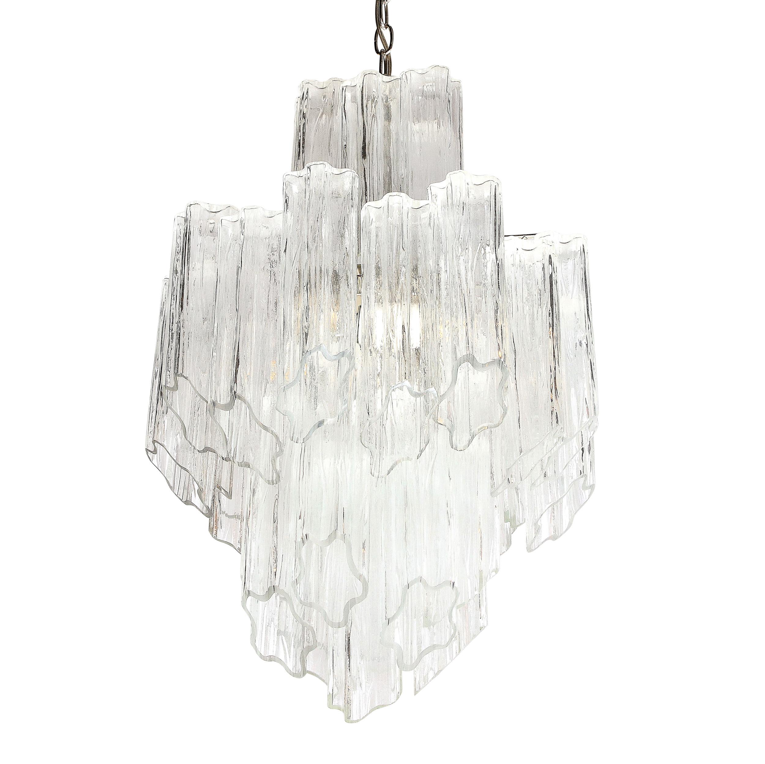 This sophisticated and graphic Mid-Century Modern chandelier was realized in Murano, Italy- the island off the coast of Murano renowned for centuries for its superlative glass production- circa 1970. It features three stacked layers of handblown