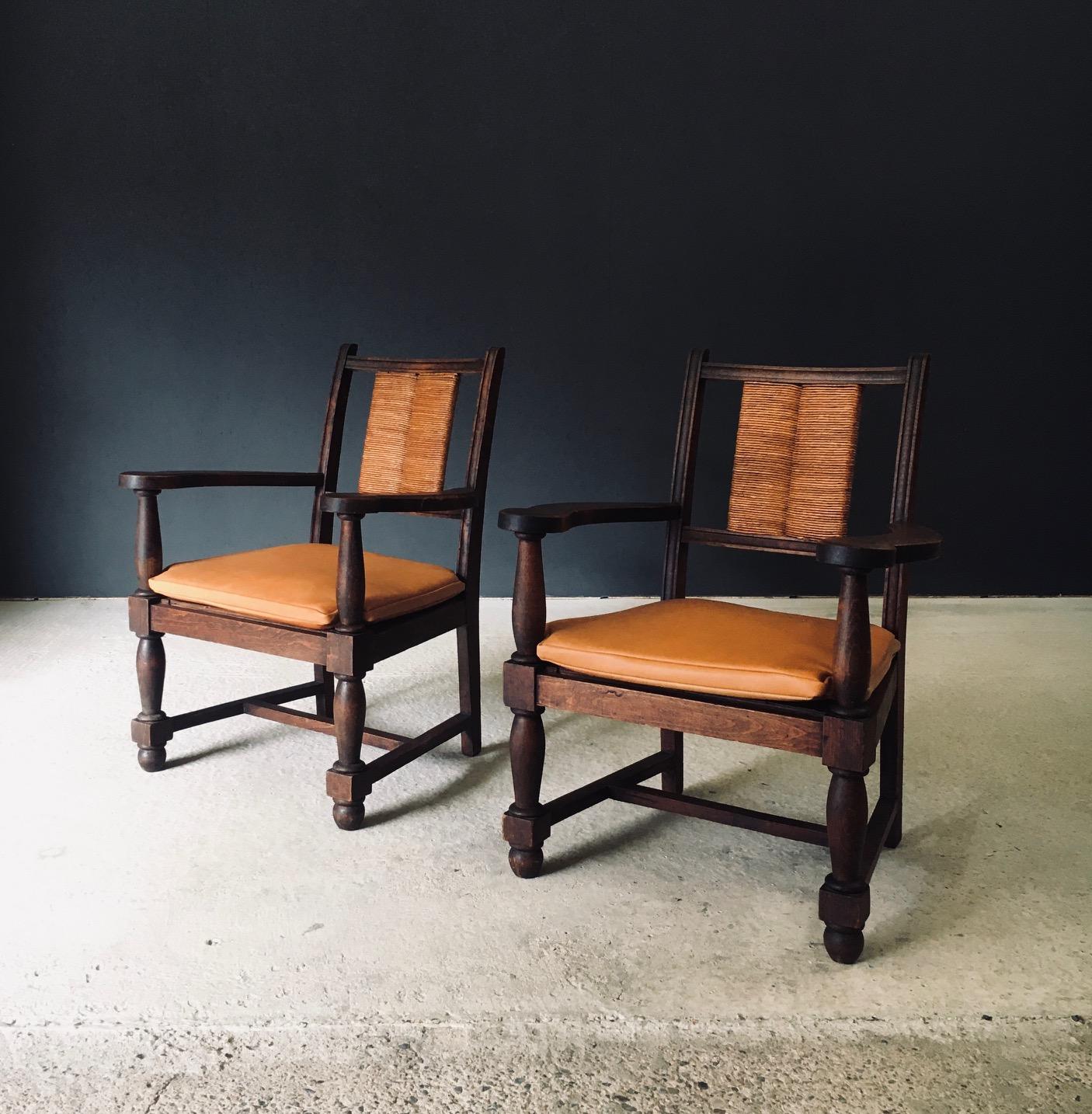 Juego de 2 sillones vintage de diseño francés modernista de mediados de siglo a la manera de Francis Jourdain. Fabricado en Francia, época años 40 / 50. Armazón de madera maciza de roble con respaldo tejido de junco y detalles tallados y torneados.