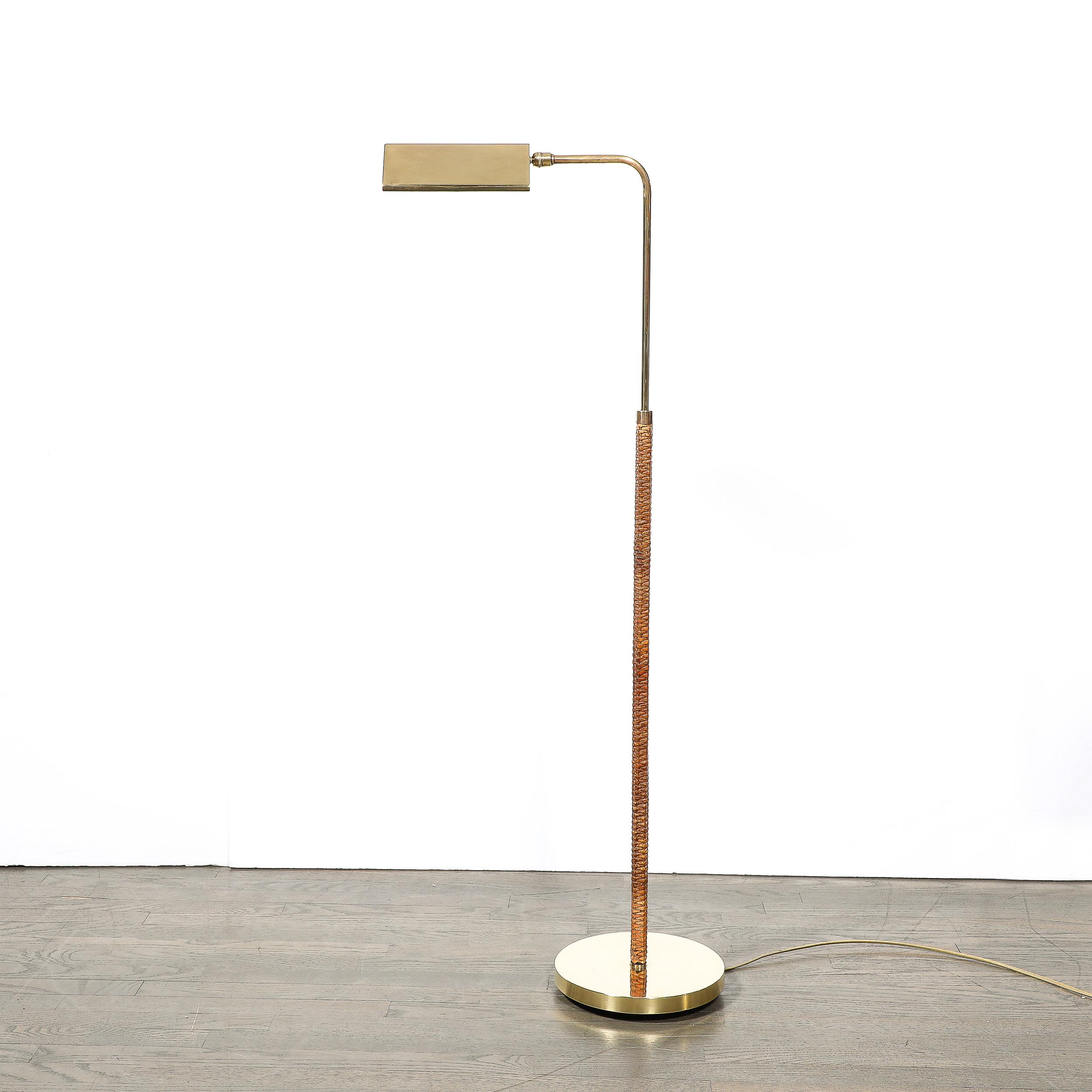 This highly sophisticated and materially exquisite Mid-Century Modernist Articulating Polished Brass and Ratan Wrapped Floor Lamp originates from the United States, Circa 1970. Features a rounded base leading to a rattan wrapped body from which an