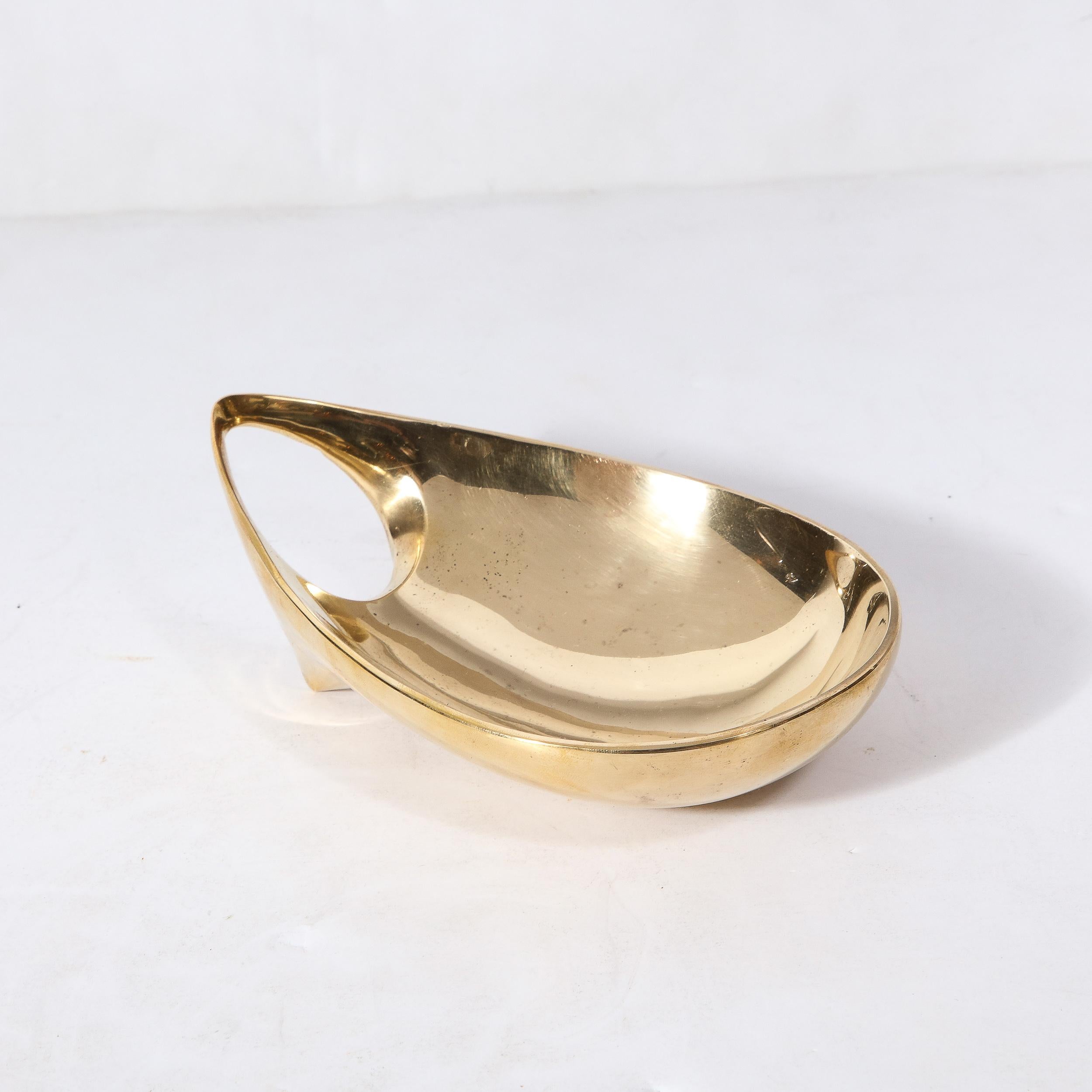 This beautifully designed Mid-Century Modernist Brass Bowl was made by the esteemed artist Carl Aubock and originates from Austria, Circa 1950. Features an oblong composition with a rounded opening achieved on one end of the dish, beautifully