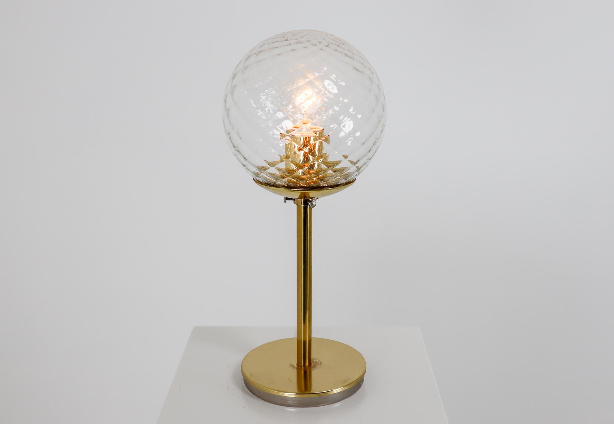 European midcentury table lamps in brass and structure glass globes. The structure glass globes density that create a wonderful light effect. These table lamp will contribute to a luxurious character of the interior. Perfect original condition with
